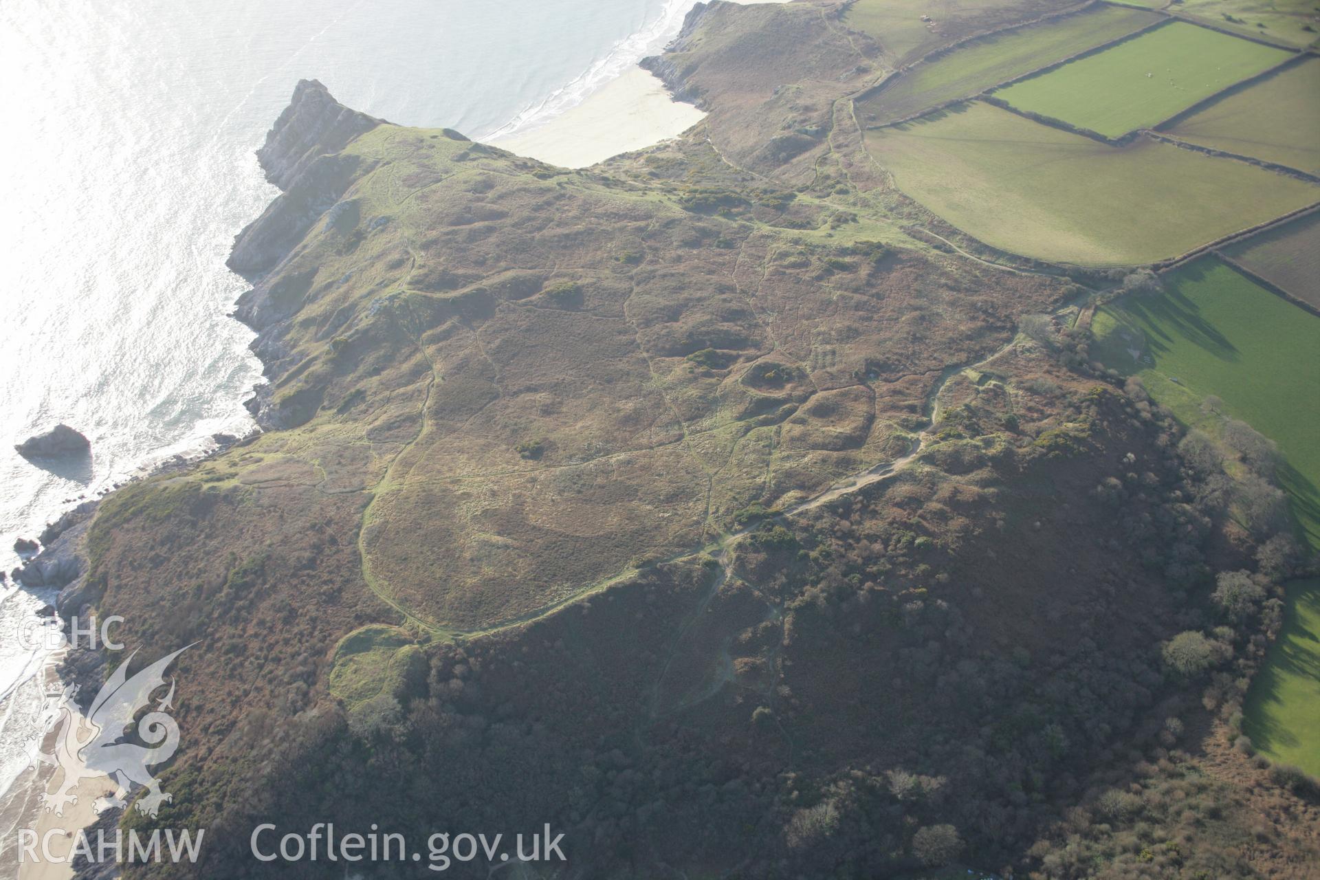 RCAHMW colour oblique aerial photograph of Castle Tower, Penmaen Burrows ringwork, wide view from the north-east. Taken on 26 January 2006 by Toby Driver