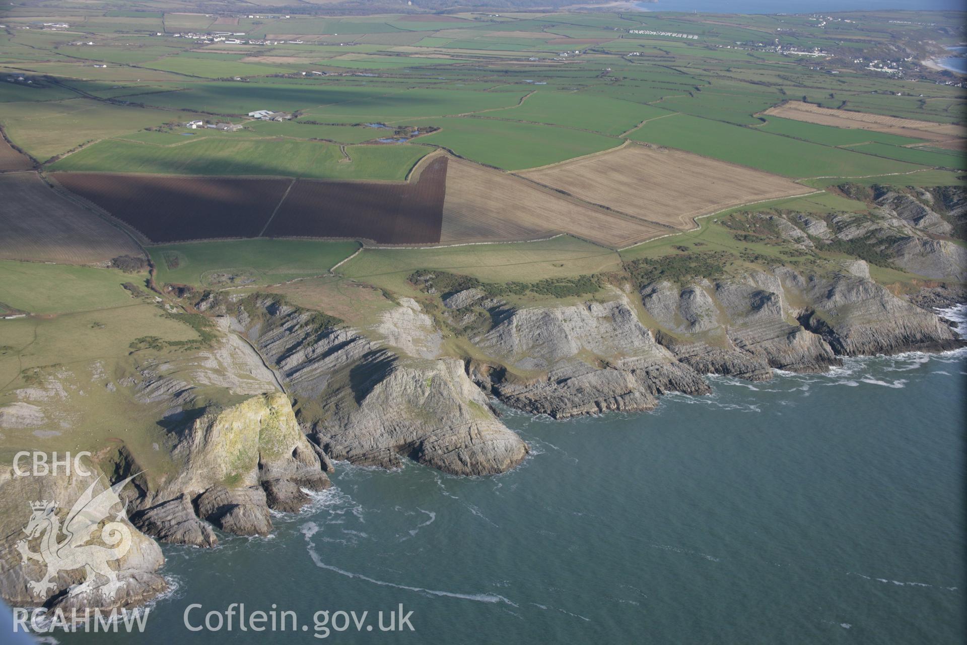 RCAHMW colour oblique aerial photograph of Goat's Hole Cave, Paviland, showing the coastal cliffs from the west. Taken on 26 January 2006 by Toby Driver.