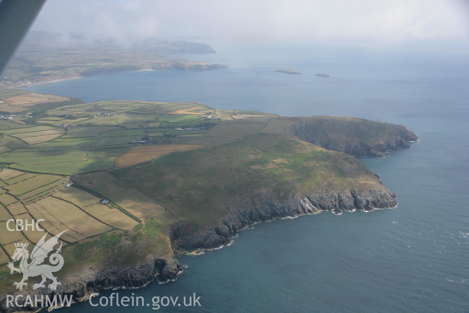 RCAHMW colour oblique aerial photograph of an enclosure on Mynydd Bwchestyn, in landscape view from the west. Taken on 03 August 2006 by Toby Driver