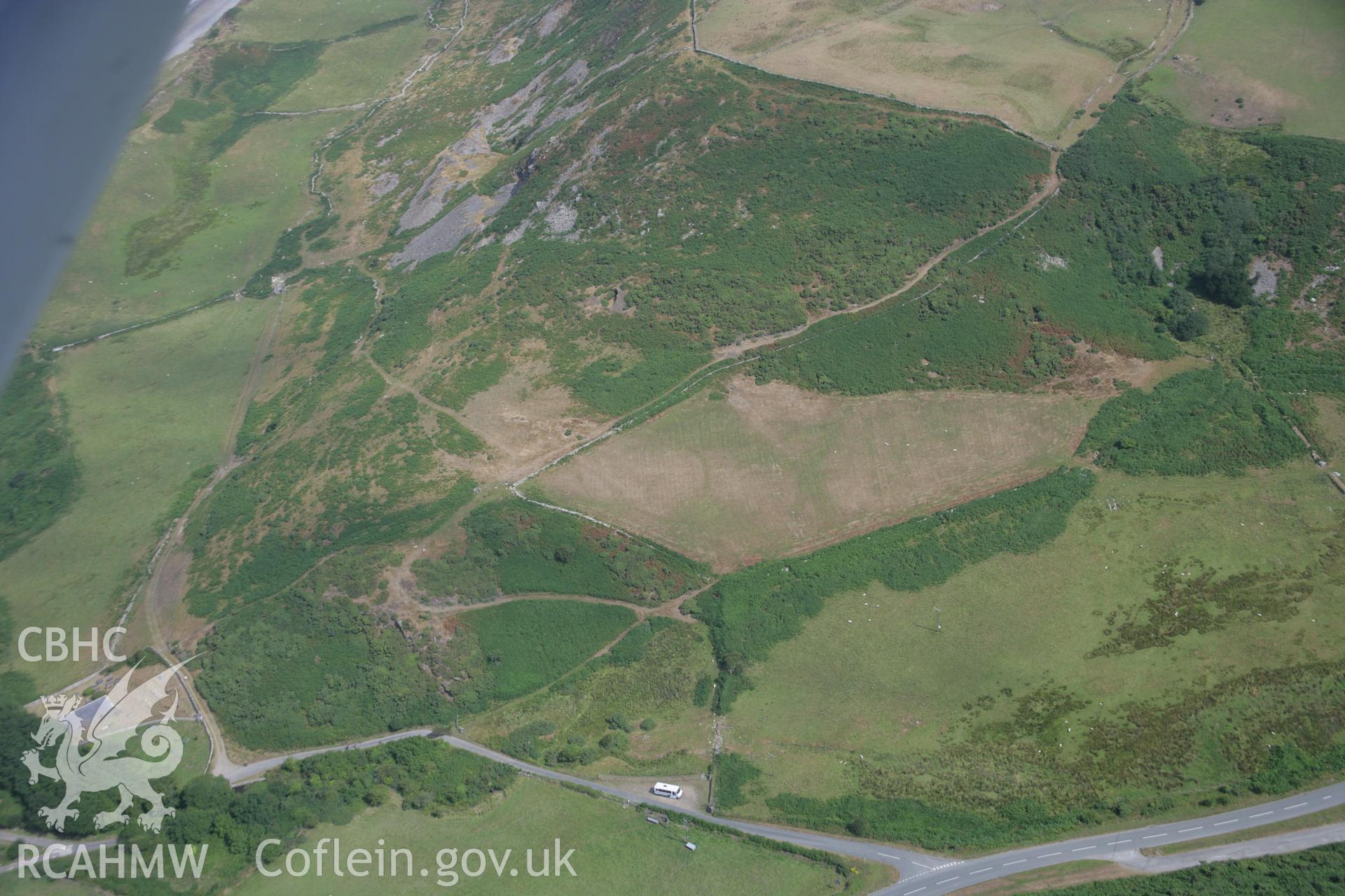 RCAHMW colour oblique aerial photograph of showing parchmark indicating possible Defended Enclosure, Pistyll, viewed from the south. Taken on 03 August 2006 by Toby Driver.