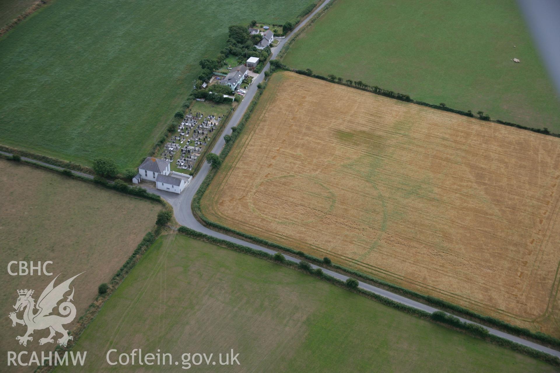 RCAHMW colour oblique aerial photograph of a cropmark enclosure east of Treferedd Uchaf. Taken on 27 July 2006 by Toby Driver.