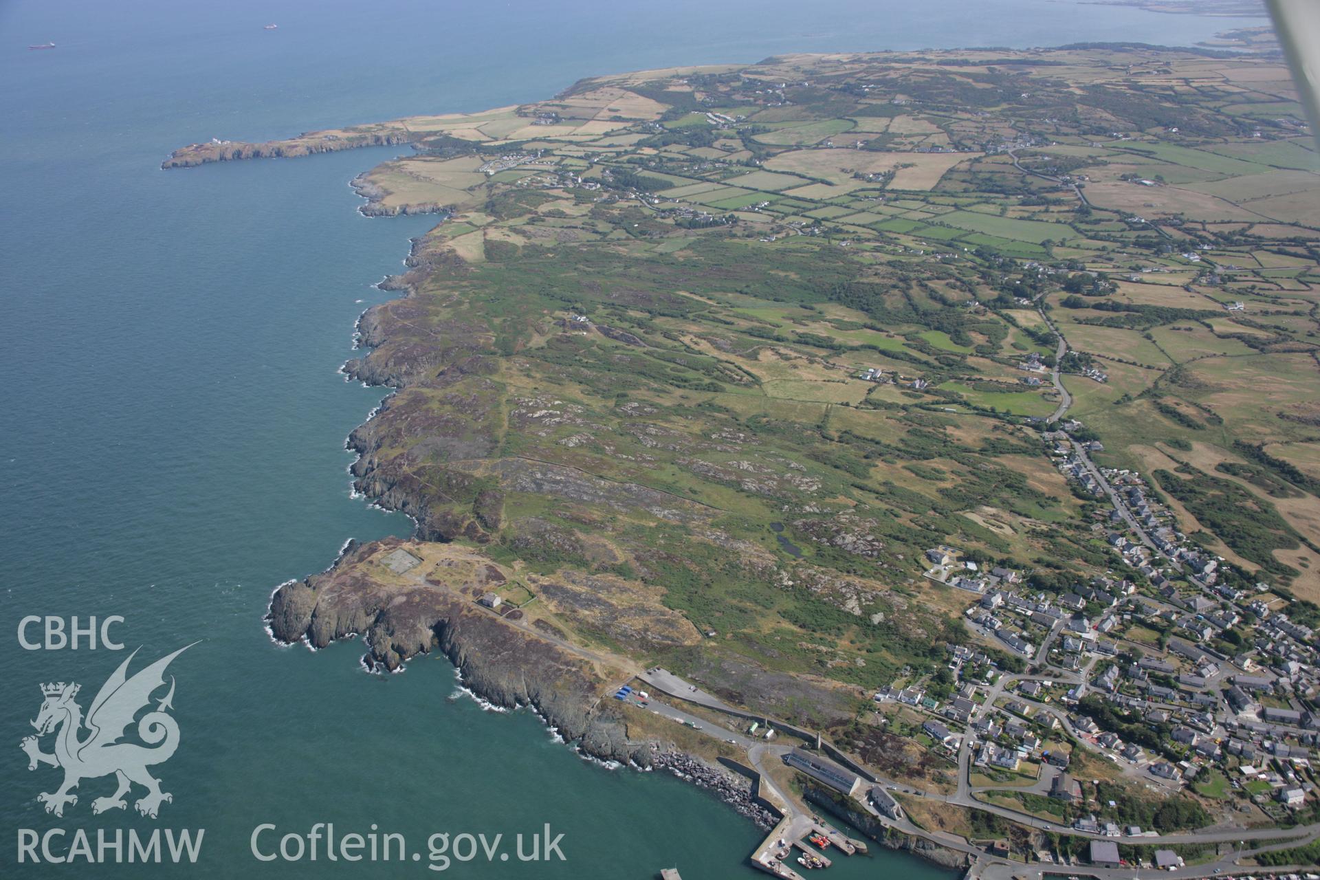 RCAHMW colour oblique aerial photograph of Porth Amlwch showing the landscape to the east. Taken on 14 August 2006 by Toby Driver.