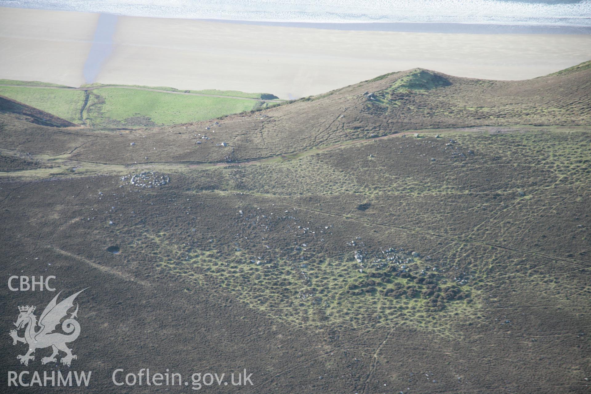 RCAHMW colour oblique aerial photograph of Rhossili Down Cairn III and The Beacon from the east with a prehistoric field boundary (NPRN 408506) also visible. Taken on 26 January 2006 by Toby Driver.