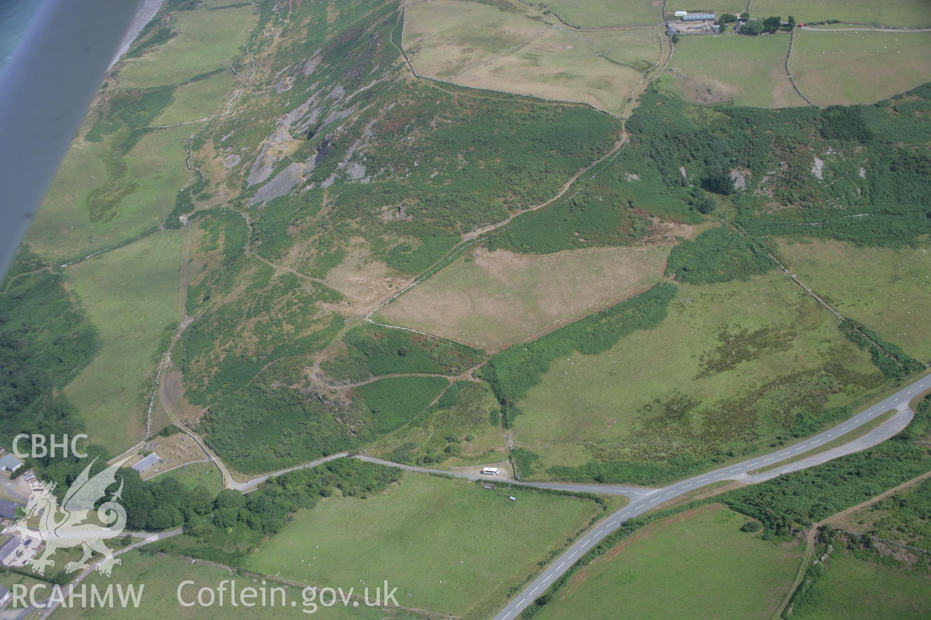 RCAHMW colour oblique aerial photograph of showing parchmark indicating possible Defended Enclosure, Pistyll, viewed from the south. Taken on 03 August 2006 by Toby Driver.