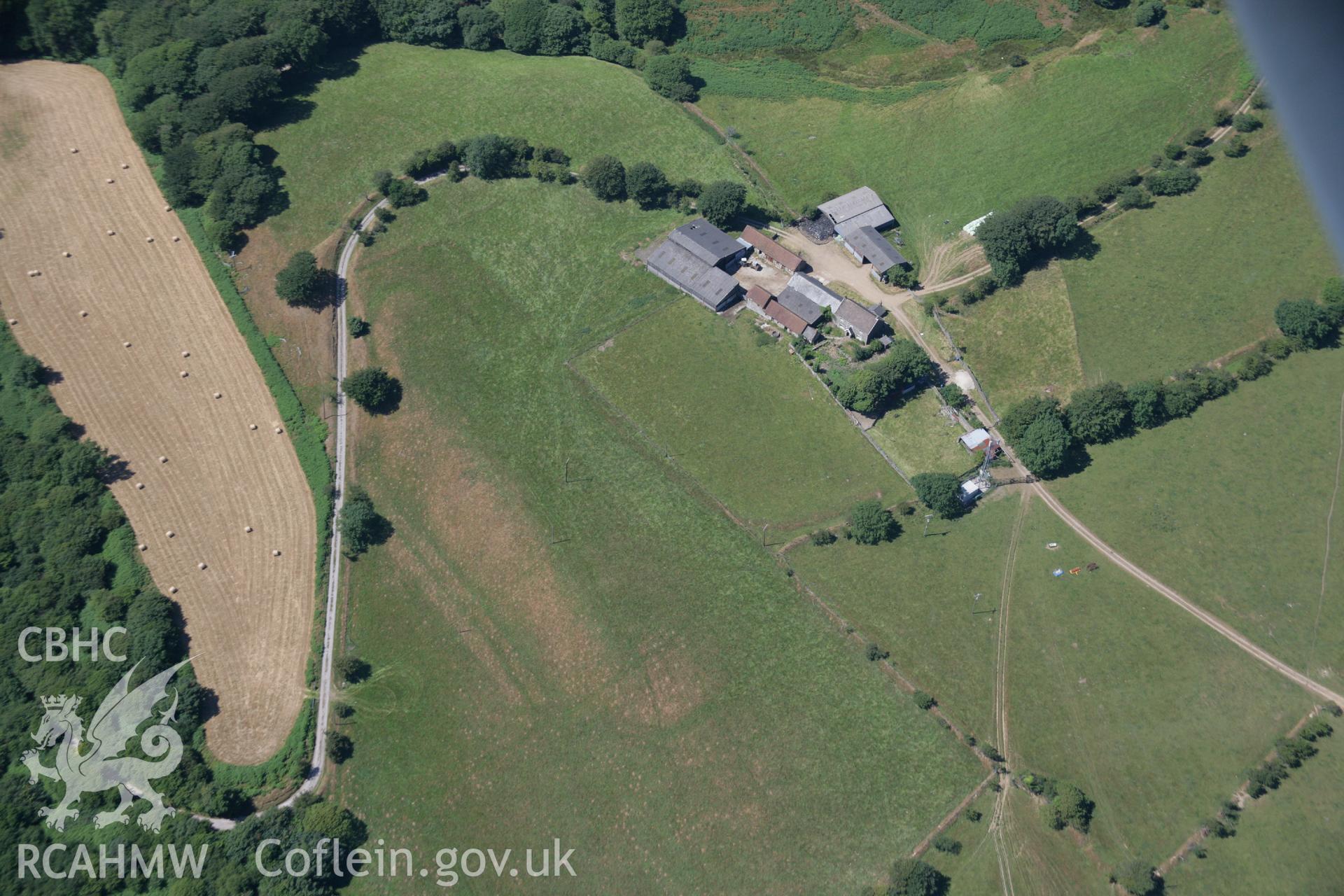 RCAHMW colour oblique aerial photograph of Ton Mawr Farm, showing earthworks that may be an indication of a hillfort. Taken on 24 July 2006 by Toby Driver.