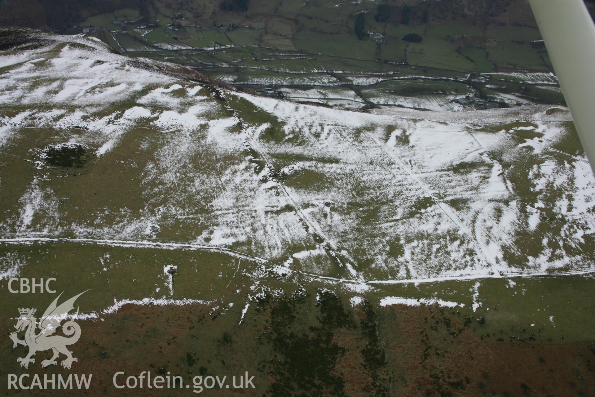 RCAHMW colour oblique aerial photograph of various undated earthworks under snow, viewed from the from the north, Garreg Fawr. Taken on 06 March 2006 by Toby Driver