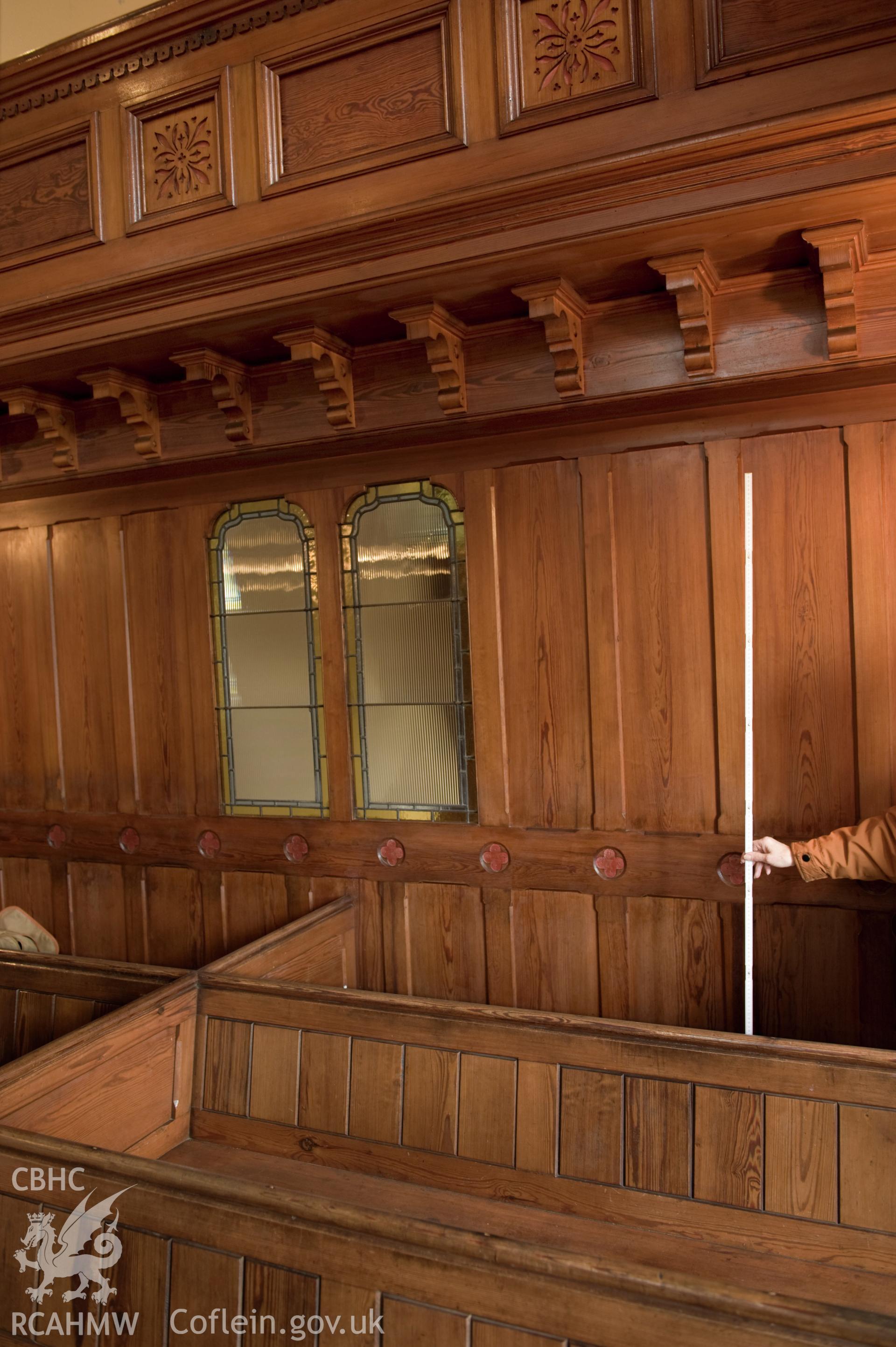 Digital image of interior with rule guide: close-up of pews and wall/ partition panelling.