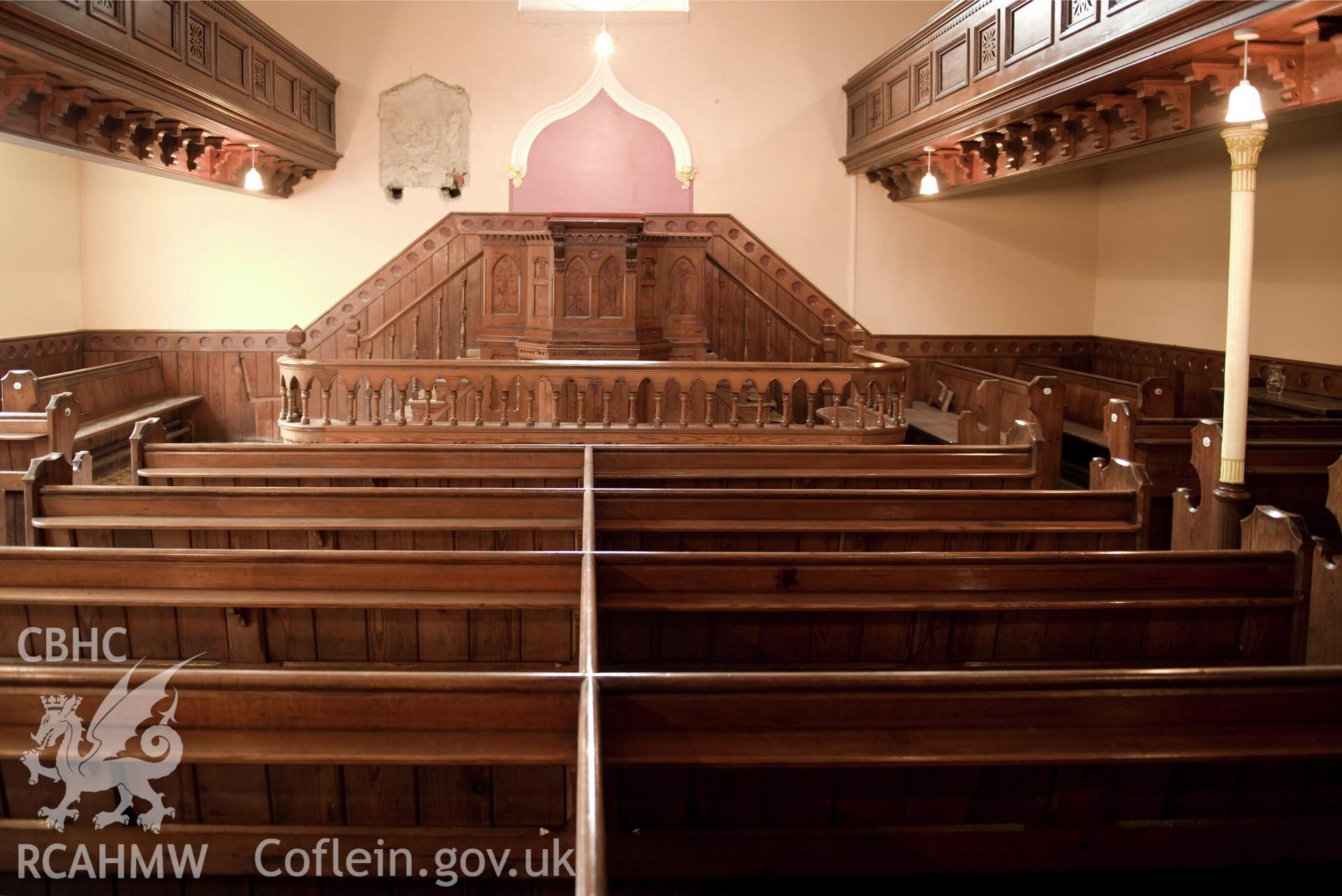 Digital image of interior: showing pulpit and pews.