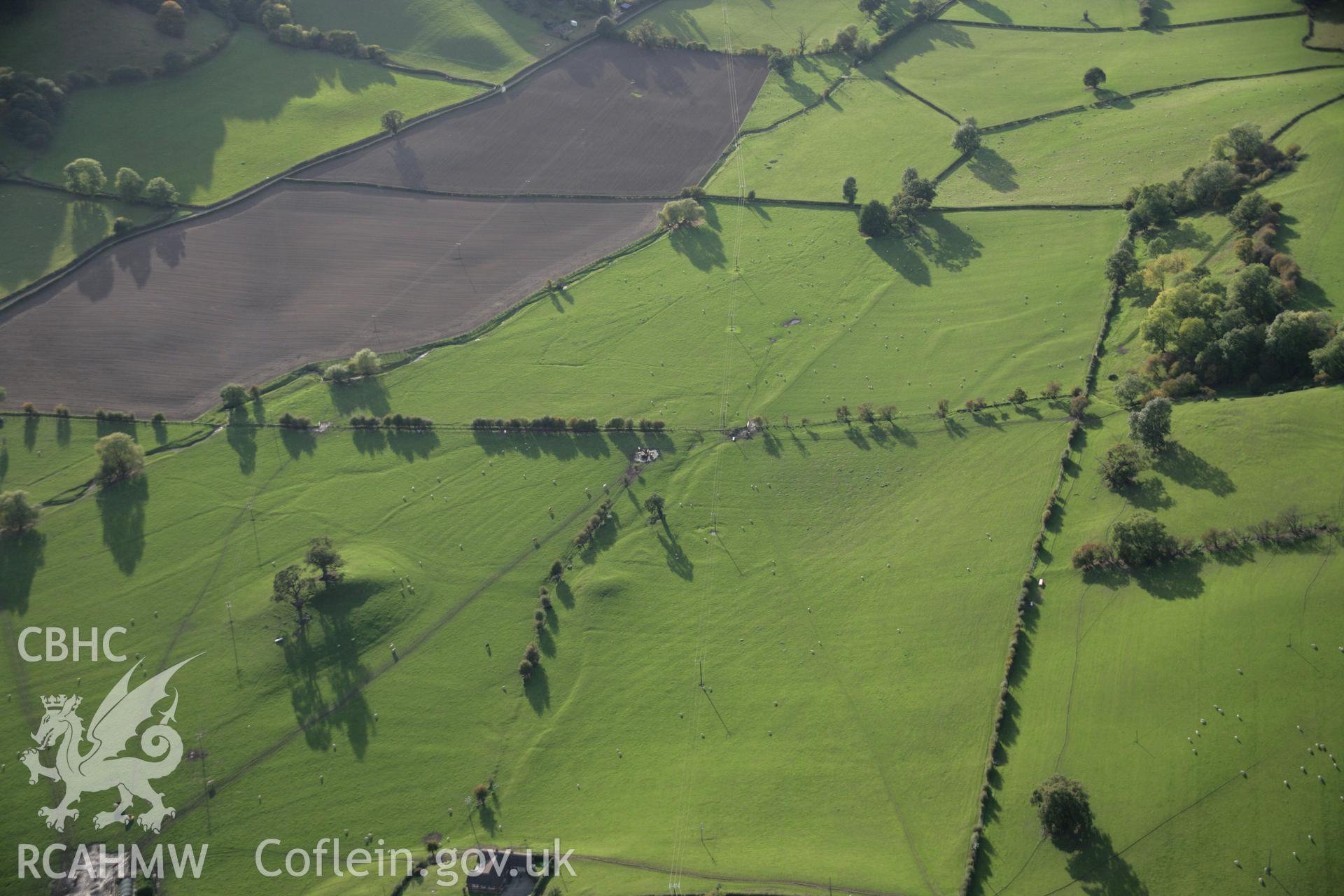 RCAHMW colour oblique aerial photograph of Llandyssil Bridge Mound with surrounding earthworks, viewed looking to the west. Taken on 13 October 2005 by Toby Driver