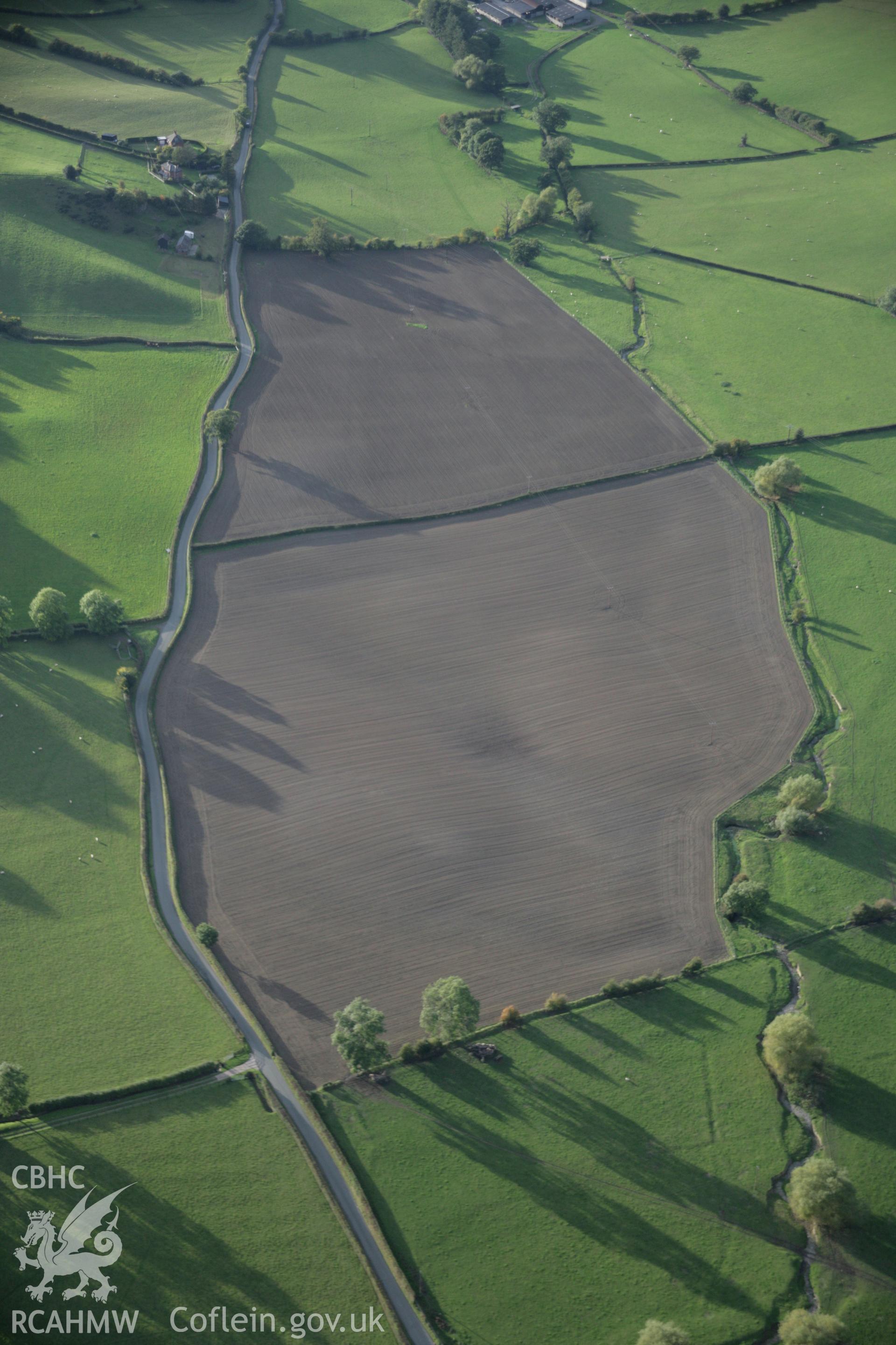 RCAHMW colour oblique aerial photograph of ploughed fields to south of Llandyssil Bridge Mound, viewed looking to the west. Taken on 13 October 2005 by Toby Driver
