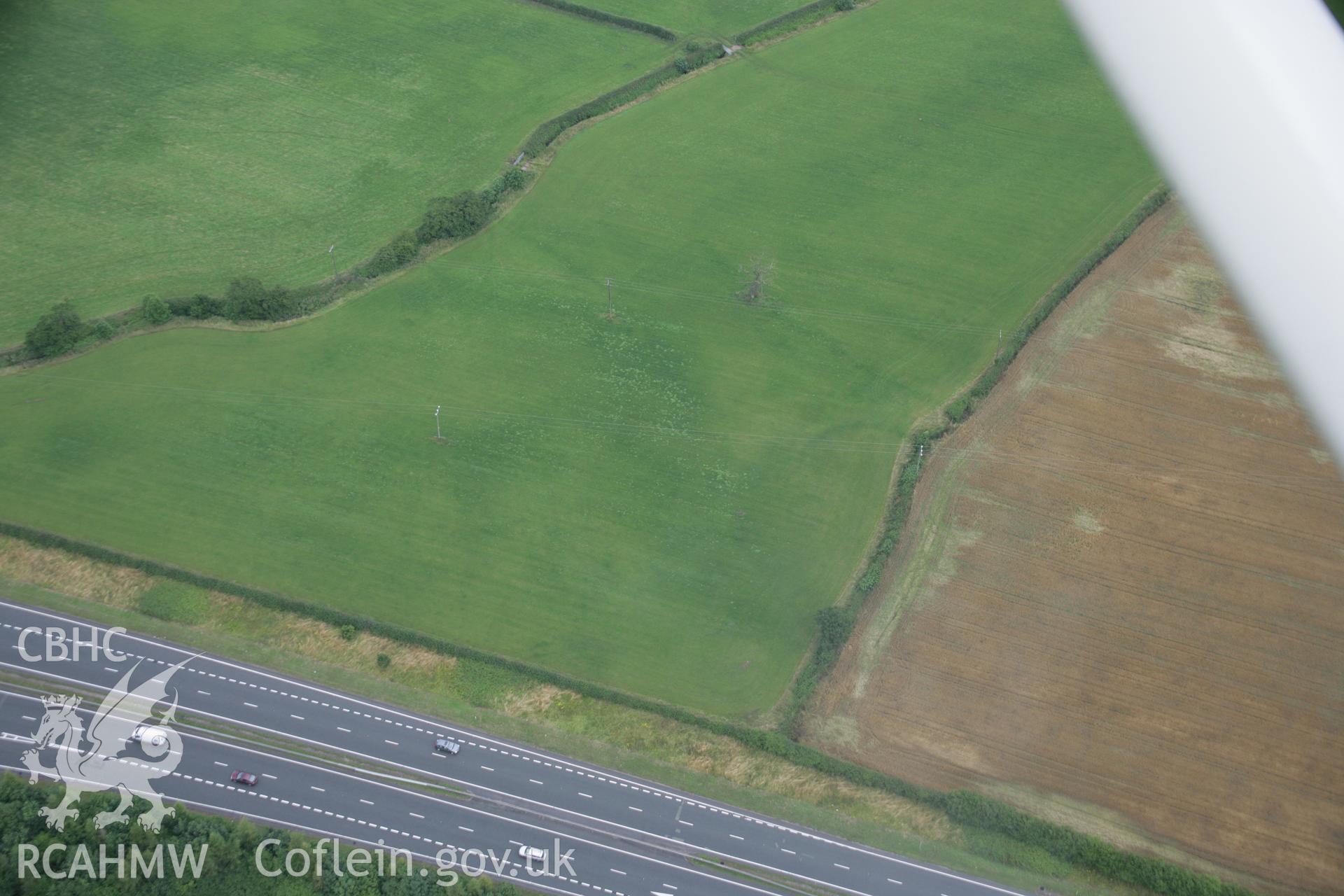 RCAHMW digital colour oblique photograph of a cropmark of a defended enclosure at Northop Brook viewed from the south-west. Taken on 01/08/2005 by T.G. Driver.