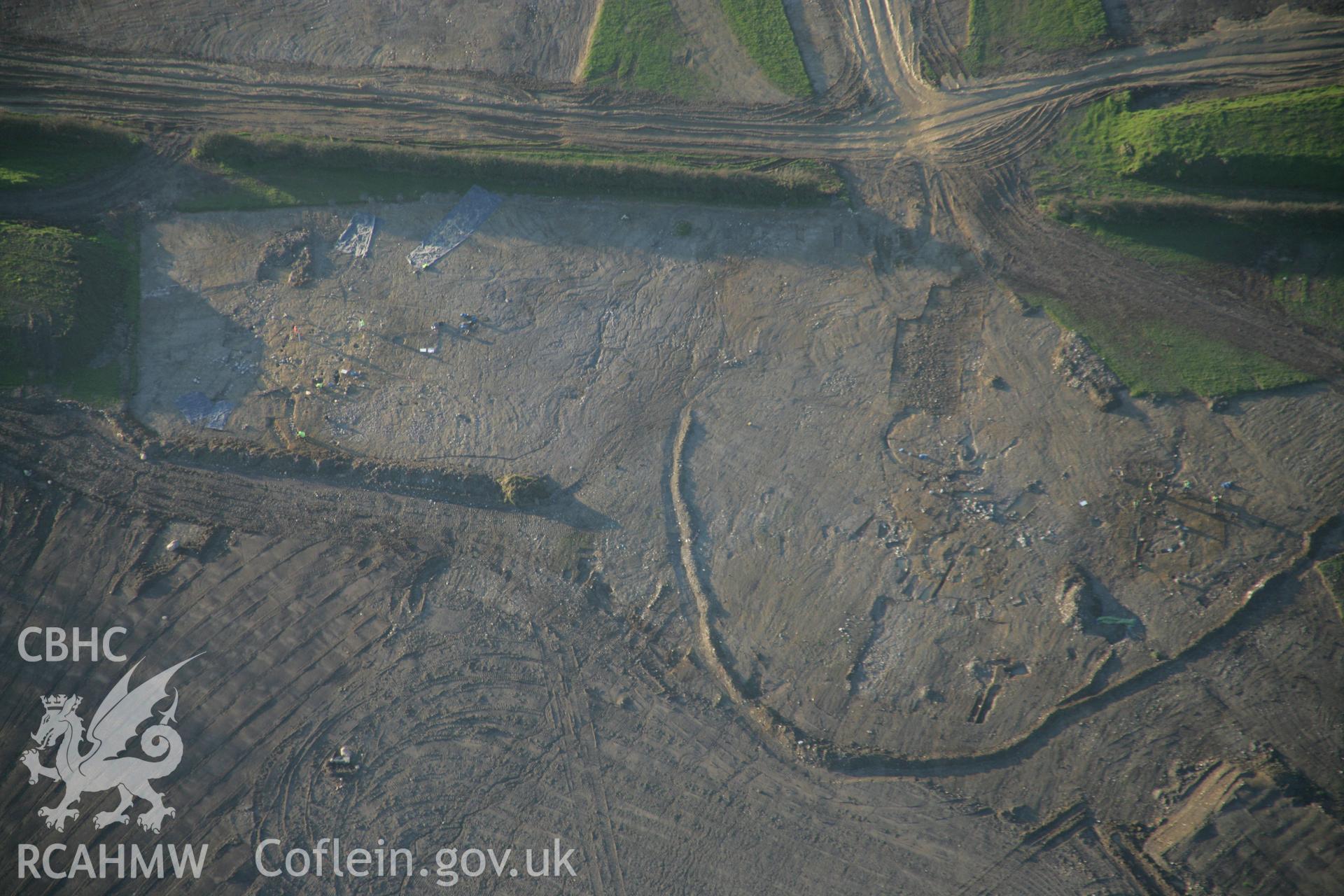 RCAHMW colour oblique aerial photograph of Parc Bryn Cegin prehistoric settlements under excavation by Gwynedd Archaeological Trust, viewed looking to the west. Taken on 21 November 2005 by Toby Driver