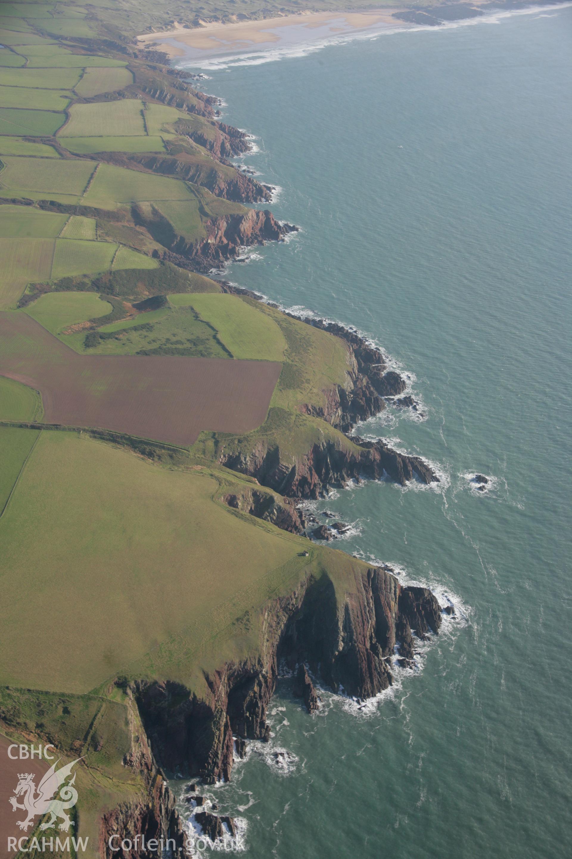 RCAHMW colour oblique aerial photograph of West Pickard Camp. A landscape view from the west showing the coastal cliffs. Taken on 19 November 2005 by Toby Driver