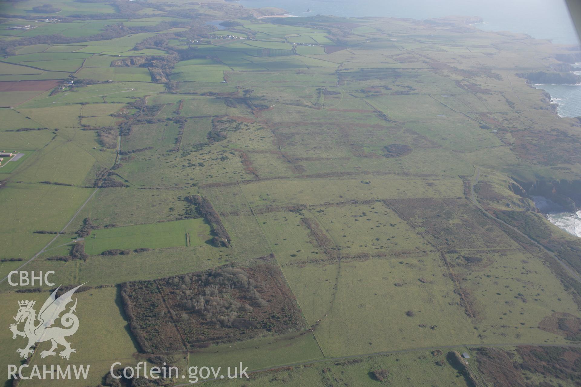 RCAHMW colour oblique aerial photograph of Longstone Down on the Castlemartin Training Area. A view looking east over the field systems and bomb craters. Taken on 19 November 2005 by Toby Driver