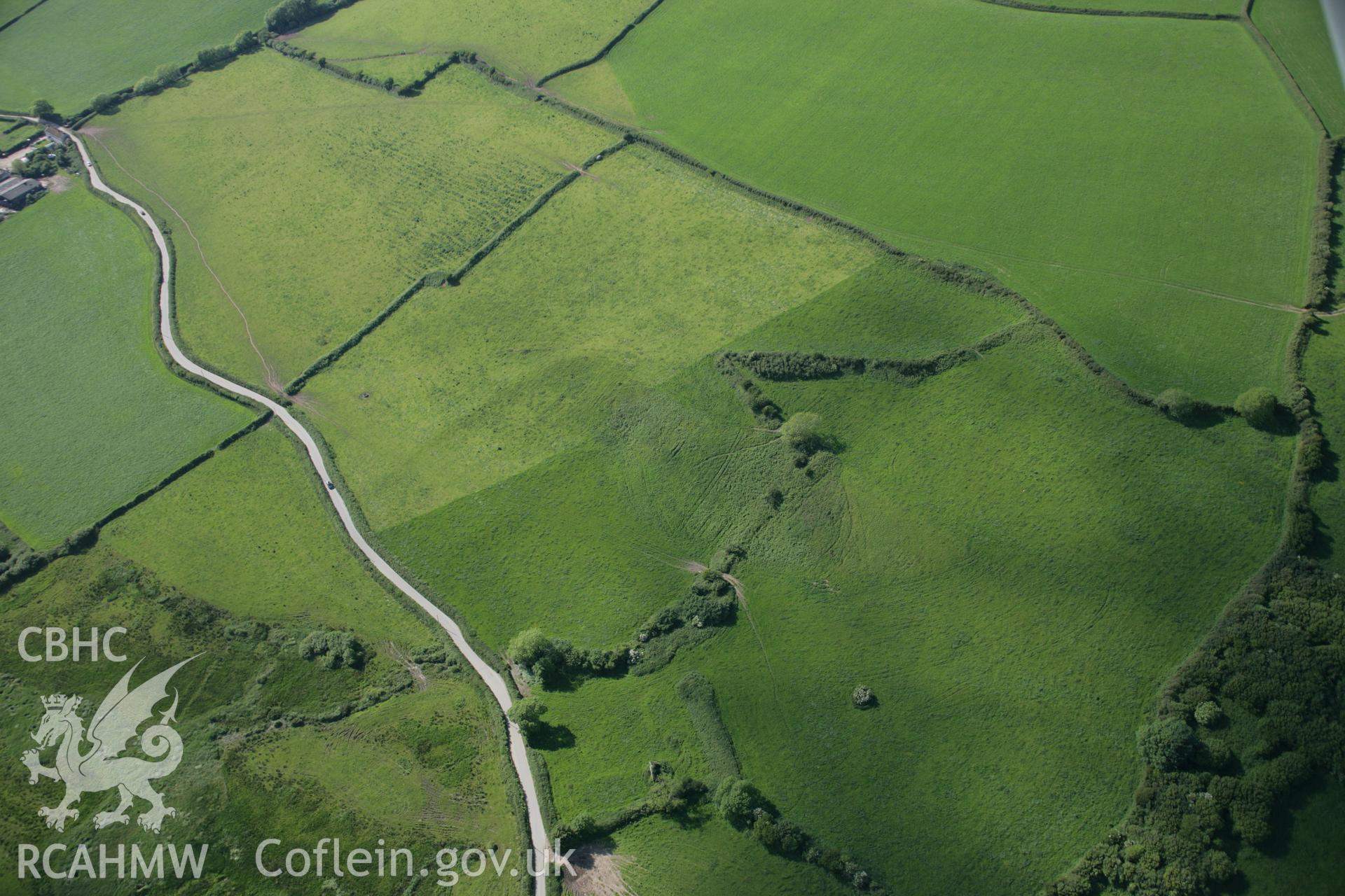RCAHMW colour oblique aerial photograph of earthworks to the west of Coleman Farm Dovecote. Taken on 09 June 2005 by Toby Driver