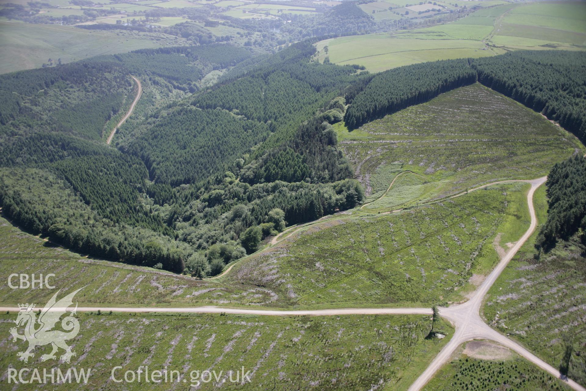 RCAHMW colour oblique aerial photograph of Geulan-Las Enclosure. A general view from the north-east after tree felling. Taken on 22 June 2005 by Toby Driver