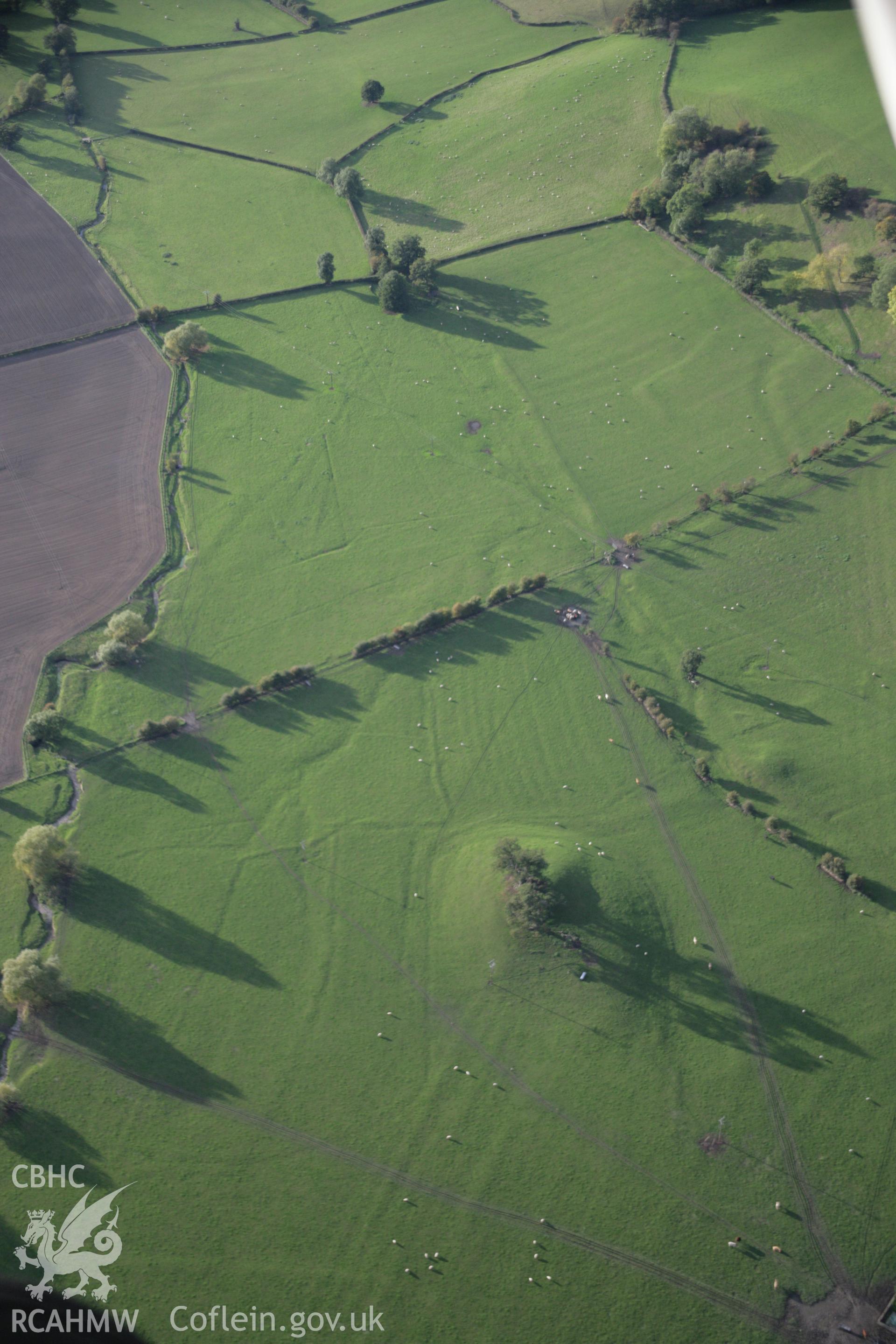 RCAHMW colour oblique aerial photograph of Llandyssil Bridge Mound with surrounding earthworks, viewed looking to the west Taken on 13 October 2005 by Toby Driver