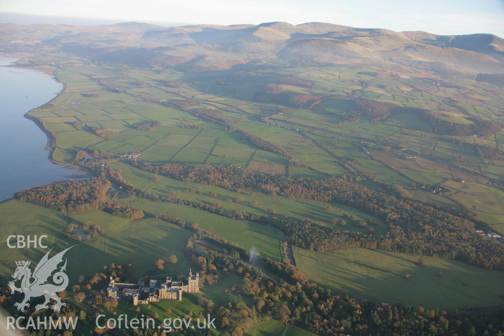 RCAHMW colour oblique aerial photograph of Penrhyn Castle Garden, Bangor, with coastal hills in panoramic view looking east from the park. Taken on 21 November 2005 by Toby Driver