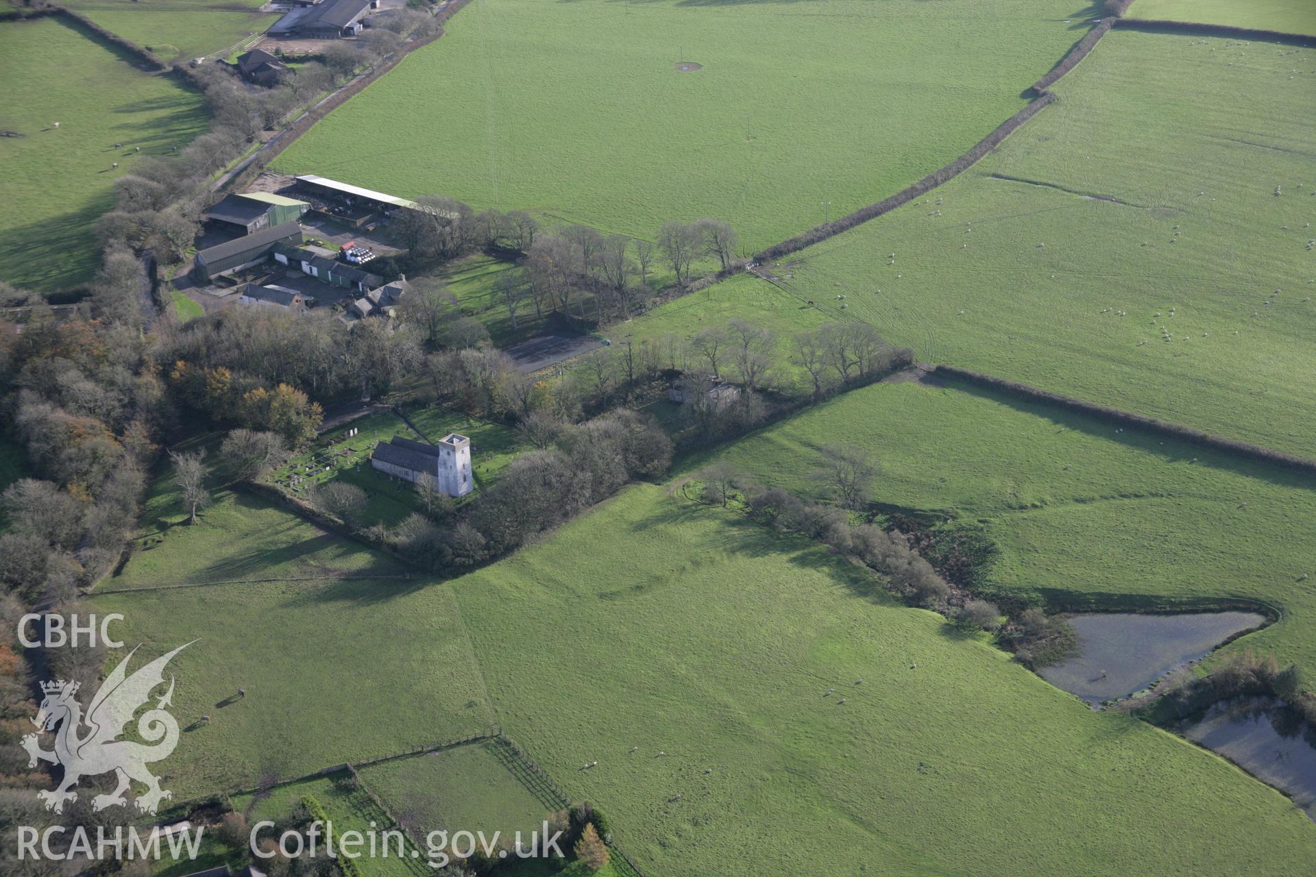 RCAHMW colour oblique photograph of Rudbaxton, church with shruken settlement earthworks, and castle beyond, view from north-west. Taken by Toby Driver on 17/11/2005.
