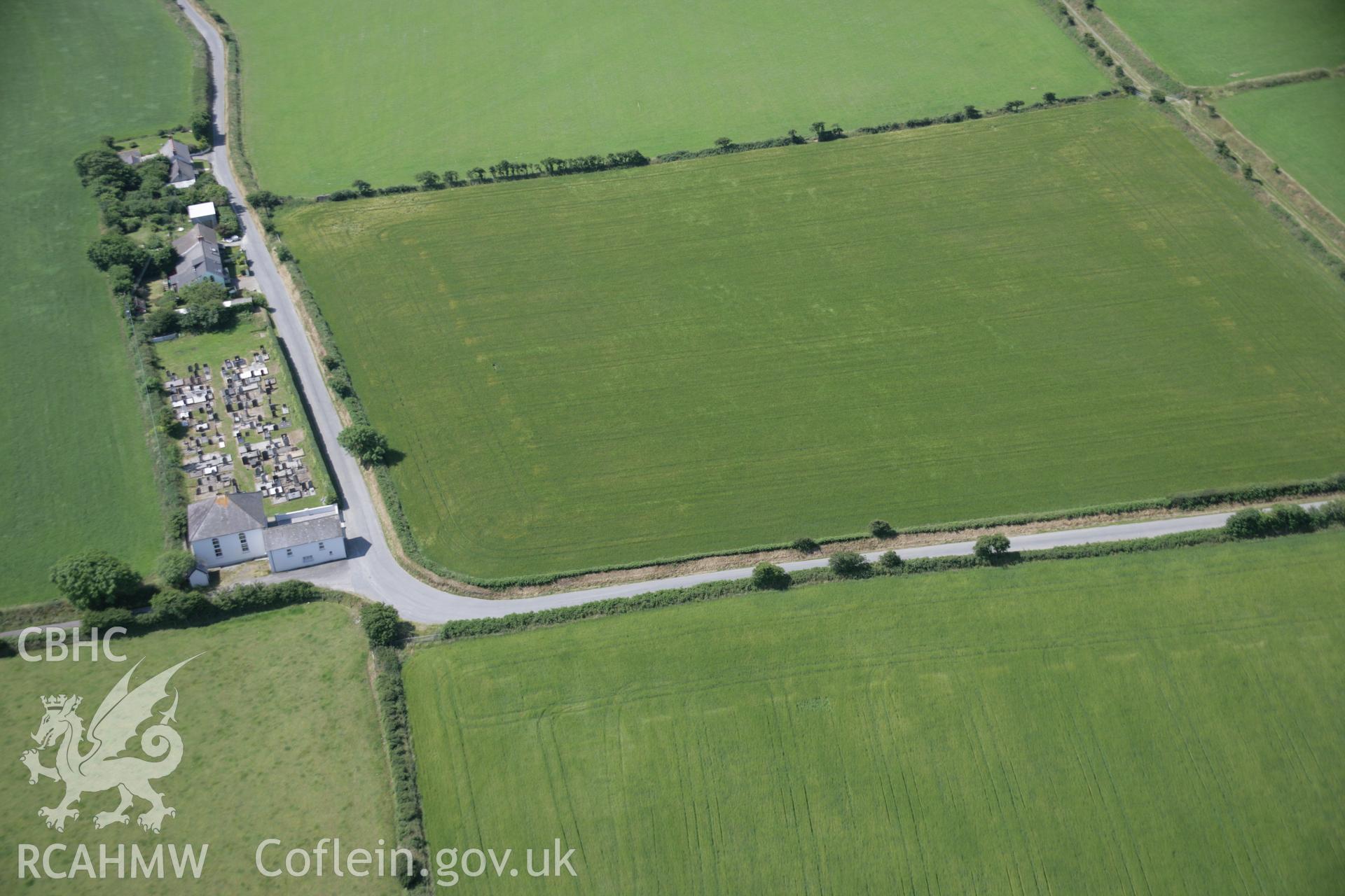 RCAHMW colour oblique aerial photograph of the site of a cropmark enclosure east of Treferedd Uchaf. Viewed from the east, but the feature is not visible. Taken on 11 July 2005 by Toby Driver