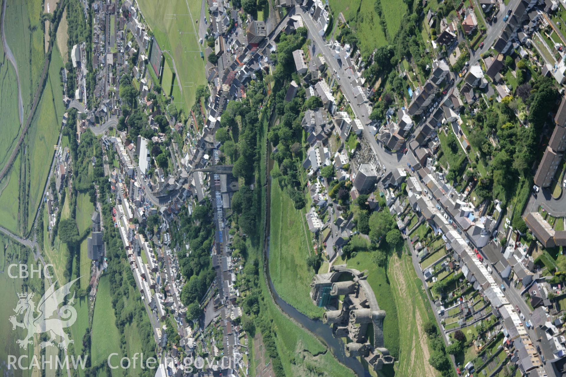 RCAHMW colour oblique aerial photograph of Kidwelly Castle and town, shown with wide view from the north-west Taken on 09 June 2005 by Toby Driver