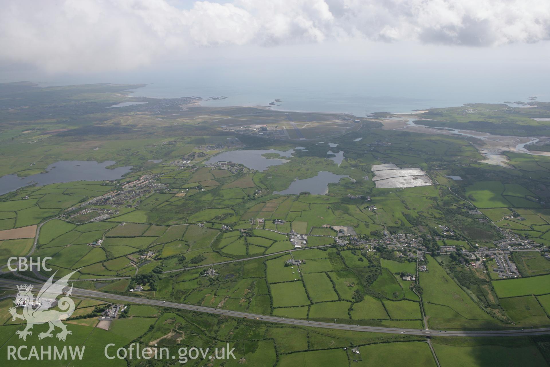 RCAHMW colour oblique photograph of view south over Llanfihangel yn Nhowyn and Llyn Penrhyn towards Anglesey Airport (Valley Airfield). Taken by Toby Driver on 13/06/2008.
