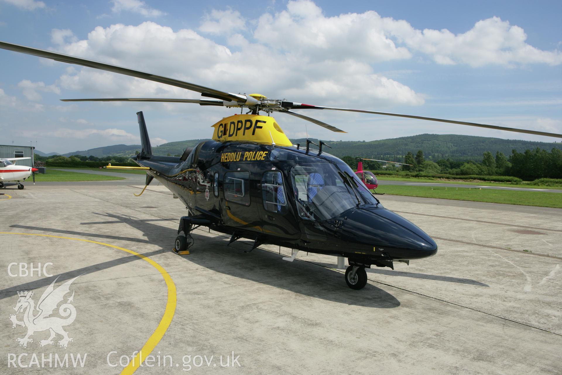 RCAHMW colour oblique photograph of police helicopter at Montgomeryshire Mid Wales Airport. Taken by Toby Driver on 01/07/2008.