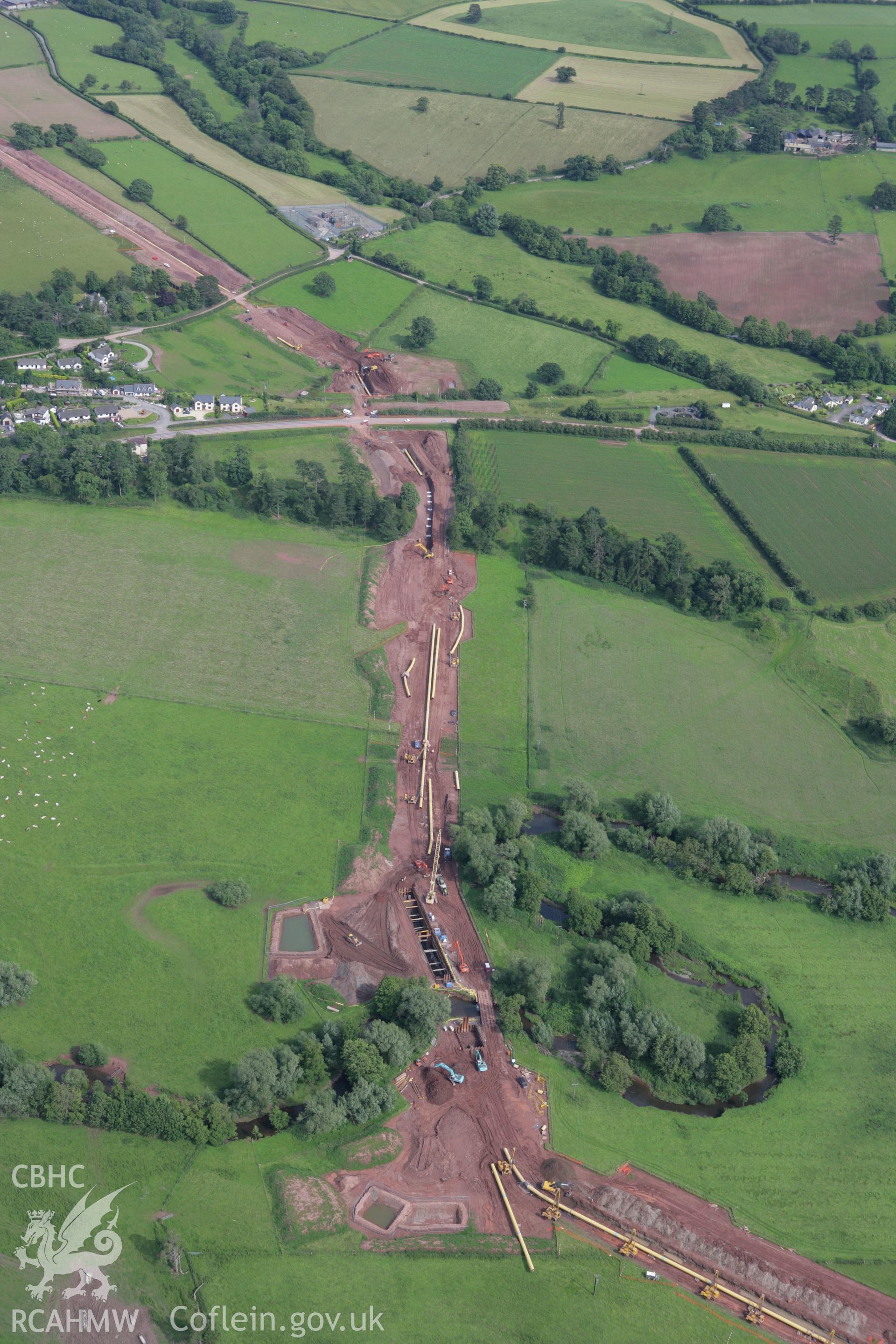 RCAHMW colour oblique aerial photograph of Aberllynfi Castle and LNG pipeline, at Glasbury looking towards the east. Taken on 09 July 2007 by Toby Driver