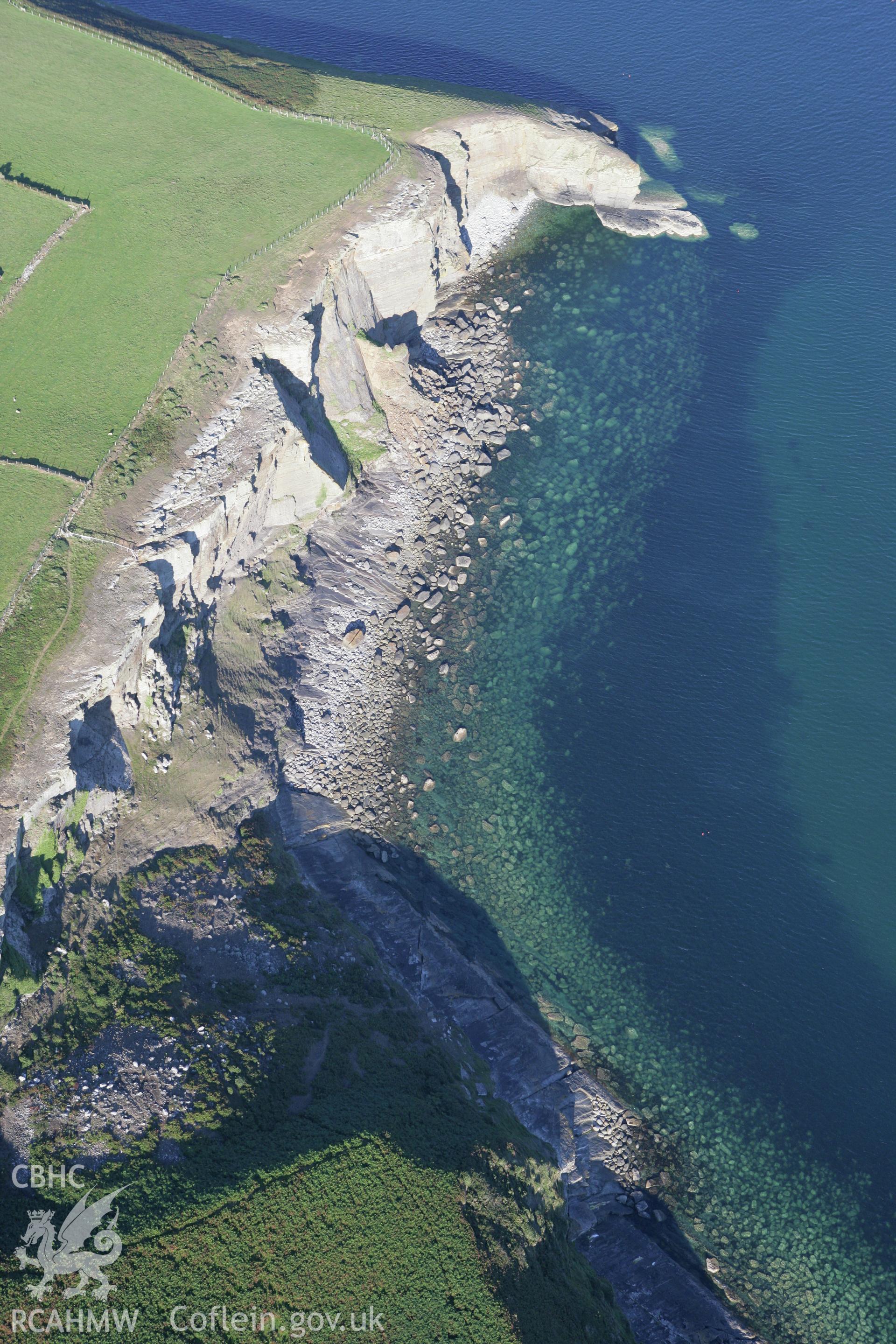 RCAHMW colour oblique aerial photograph of non-archaeological view of eroding cliff, Trwyn Llech y Doll, near Chambered Tomb Cilan Uchaf. Taken on 06 September 2007 by Toby Driver