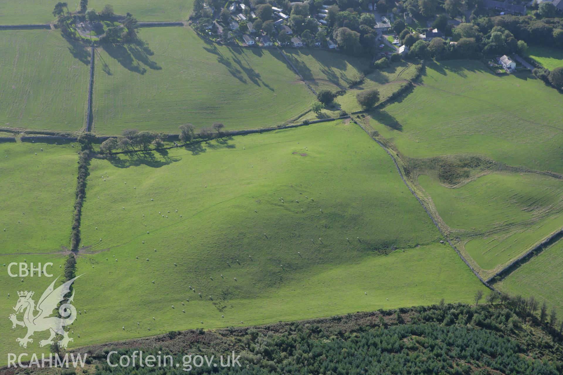 RCAHMW colour oblique aerial photograph of an earthwork enclosure in the grounds of Madryn Castle. Taken on 06 September 2007 by Toby Driver