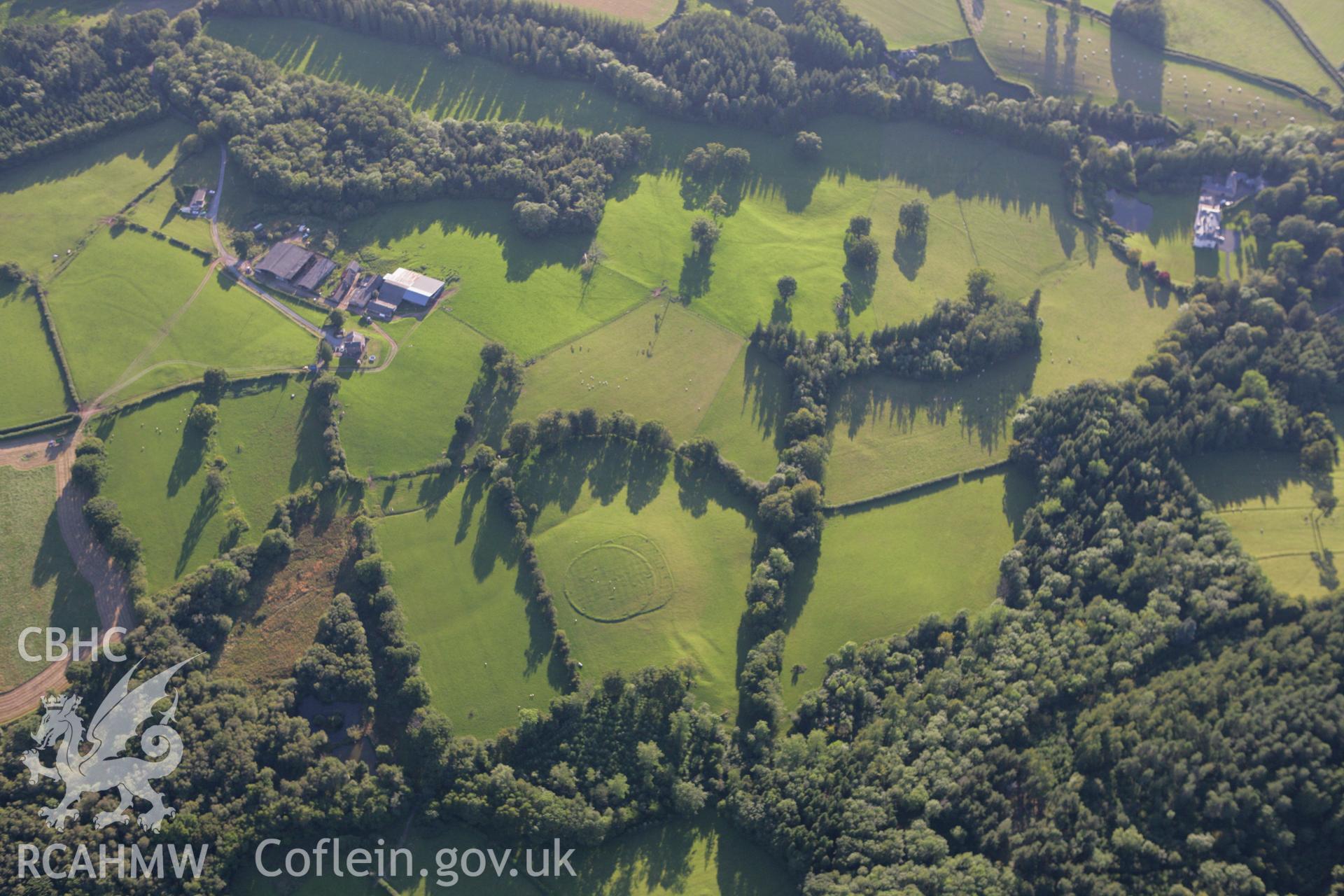 RCAHMW colour oblique aerial photograph of earthworks of post-medieval tree planting ring, Wernddu. Taken on 08 August 2007 by Toby Driver