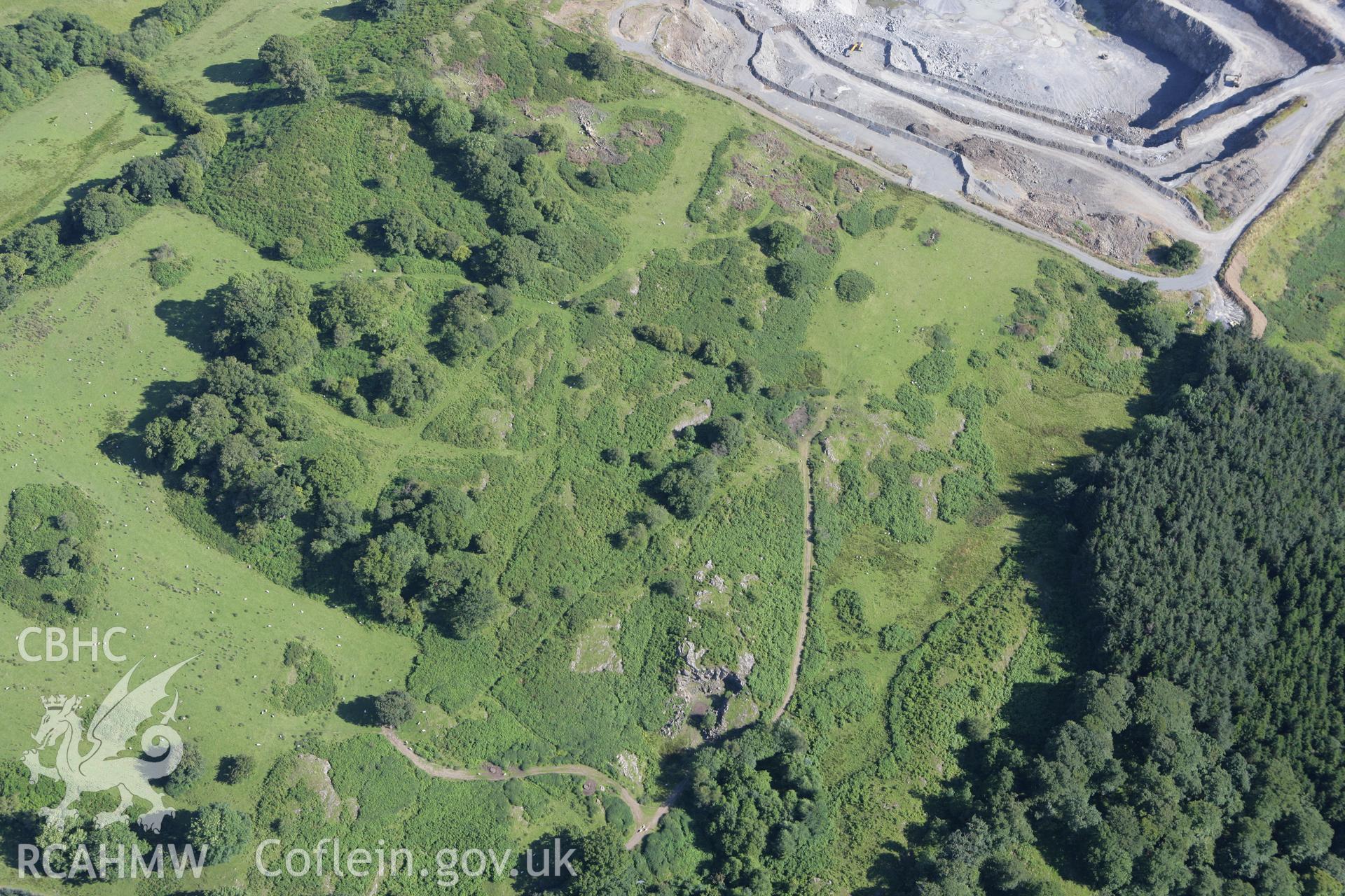 RCAHMW colour oblique aerial photograph of cairns near Llanelwedd Stone Quarry. Taken on 08 August 2007 by Toby Driver