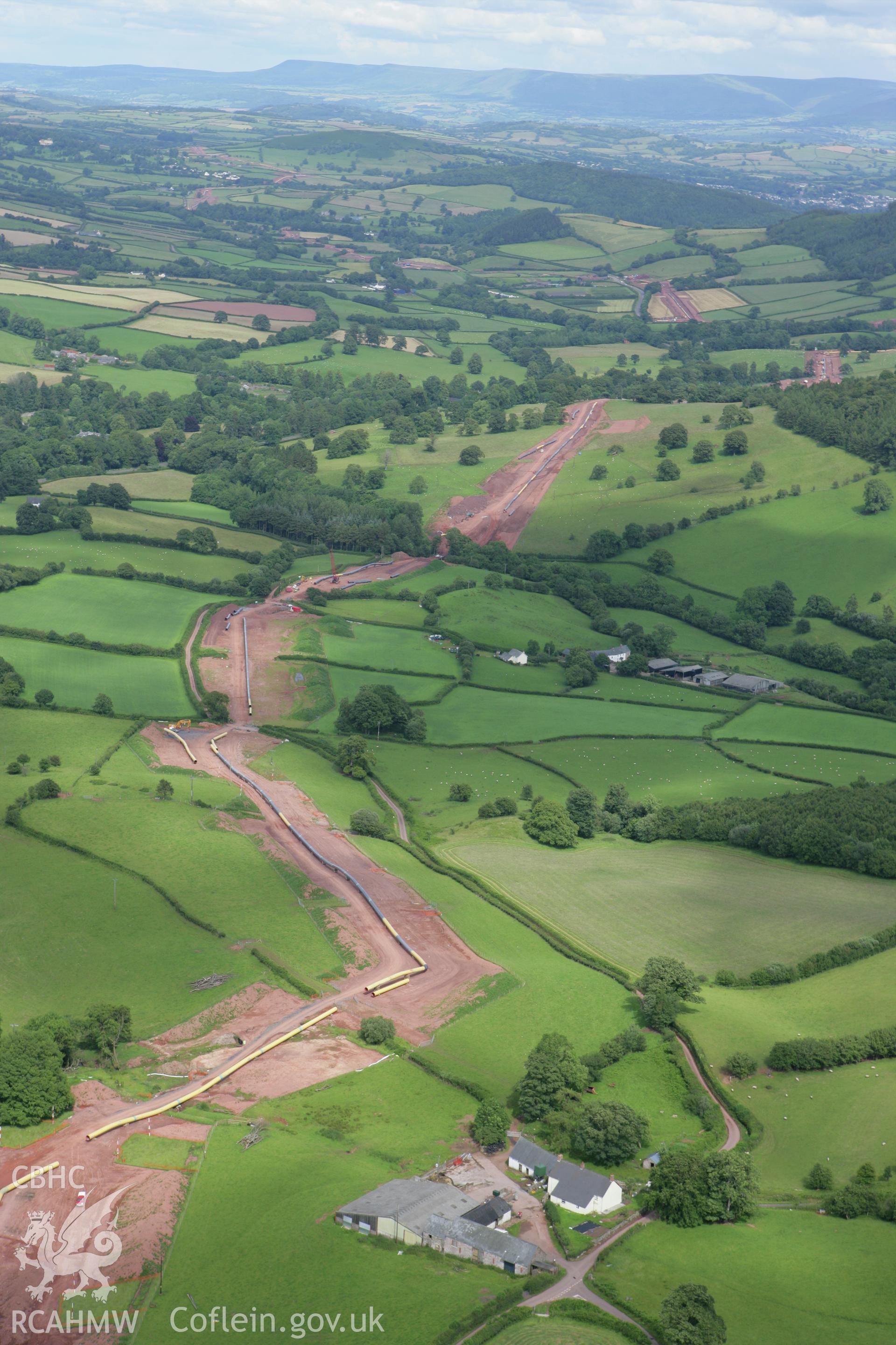 RCAHMW colour oblique aerial photograph of Maes-Car Farmhouse with LNG pipeline. Taken on 09 July 2007 by Toby Driver