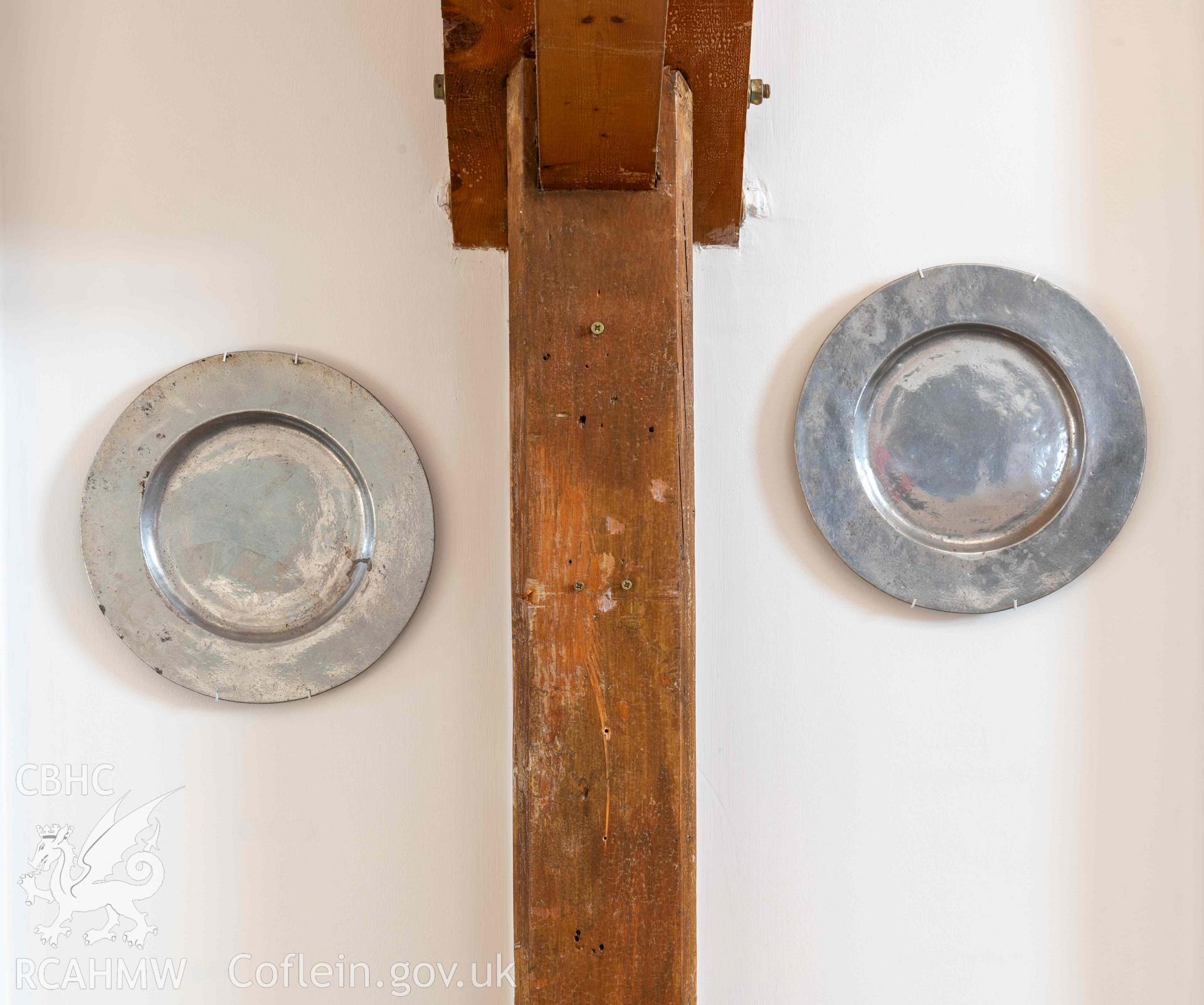 Norwegian Church - View of two metal plates hanging either side of a wooden beam, taken from North
