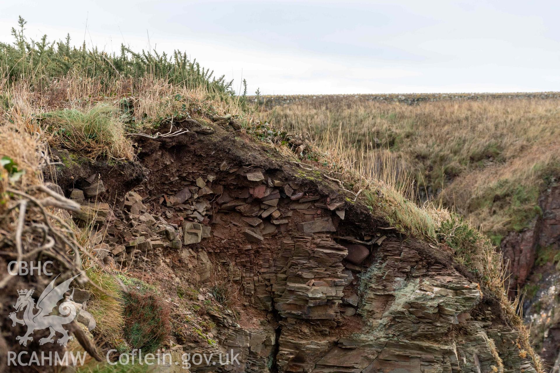 Castle Head Coastal Promontory Fort. Erosion and collapse on the western side of the fort interior exposing wall facing of the defence that once enlosing the promontory fort.