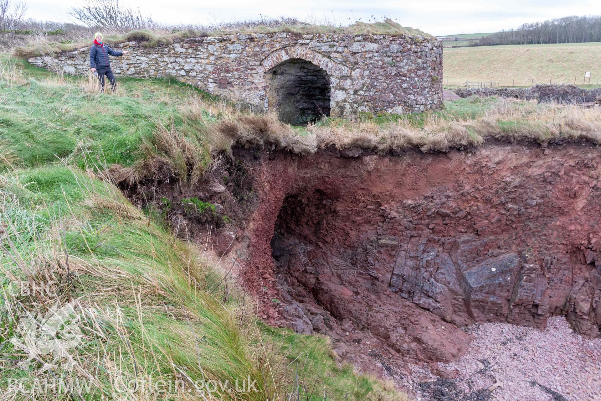 Looking southwest to St Bride's lime kiln with coast edge and undercut exposing cemetery remains.