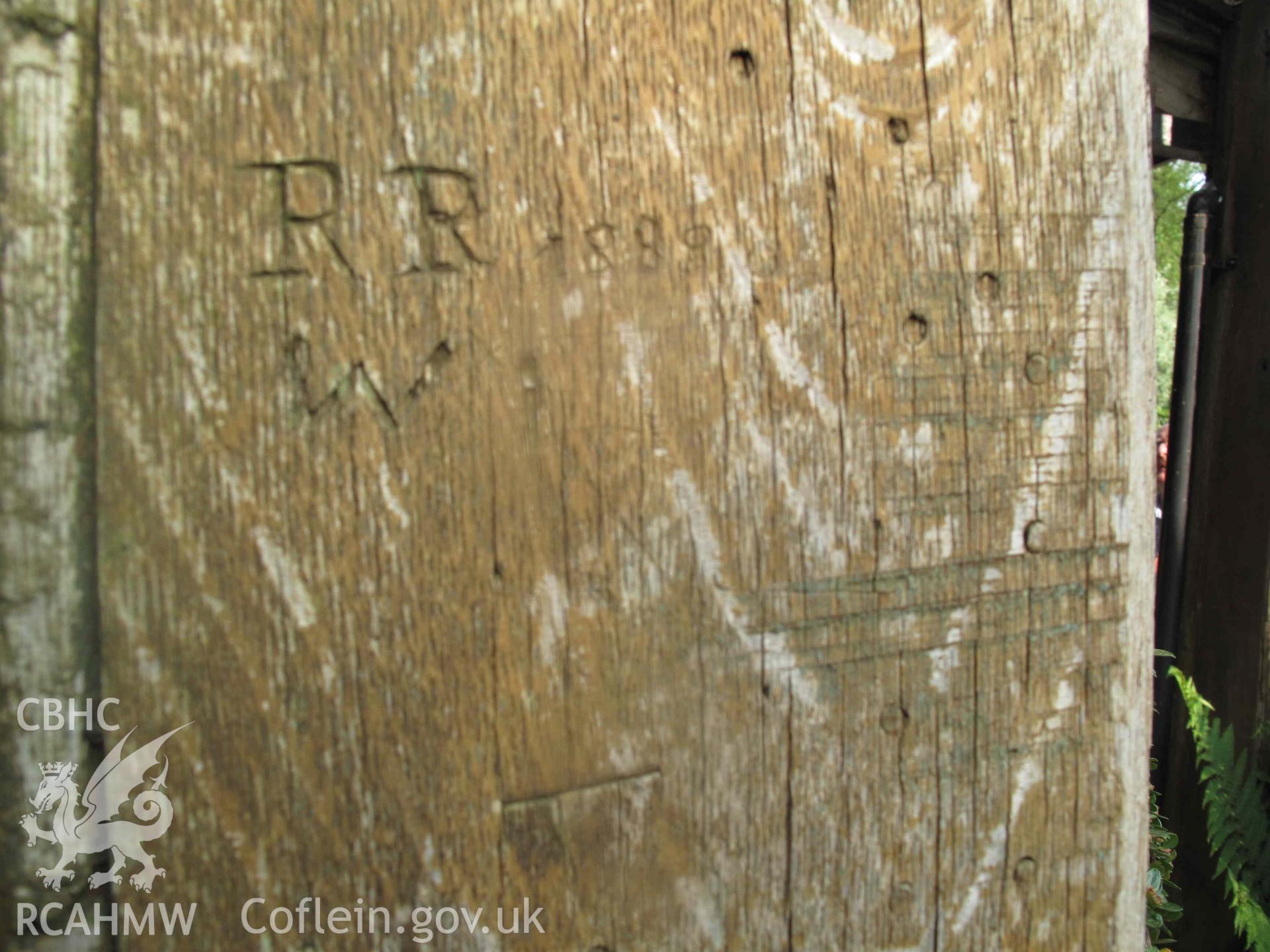 Ffatri Isaf,  Abercegir: carving on wooden post, "R R W 1888" visible.
