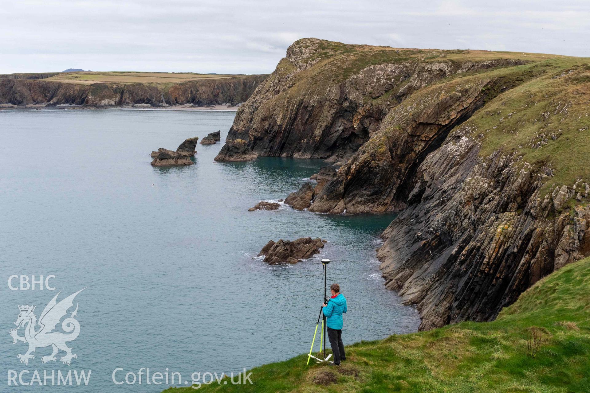 Trwyn Castell coastal promontory fort. RCAHMW investigator undertaking survey at the fort .