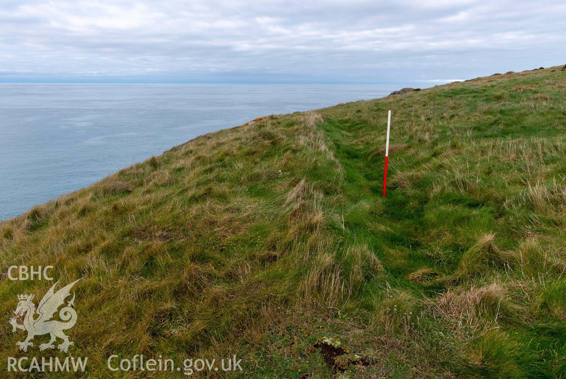 Trwyn Castell coastal promontory fort. External (east) side of the outer defence which rises above the narrowest point of the promontory (with scale).