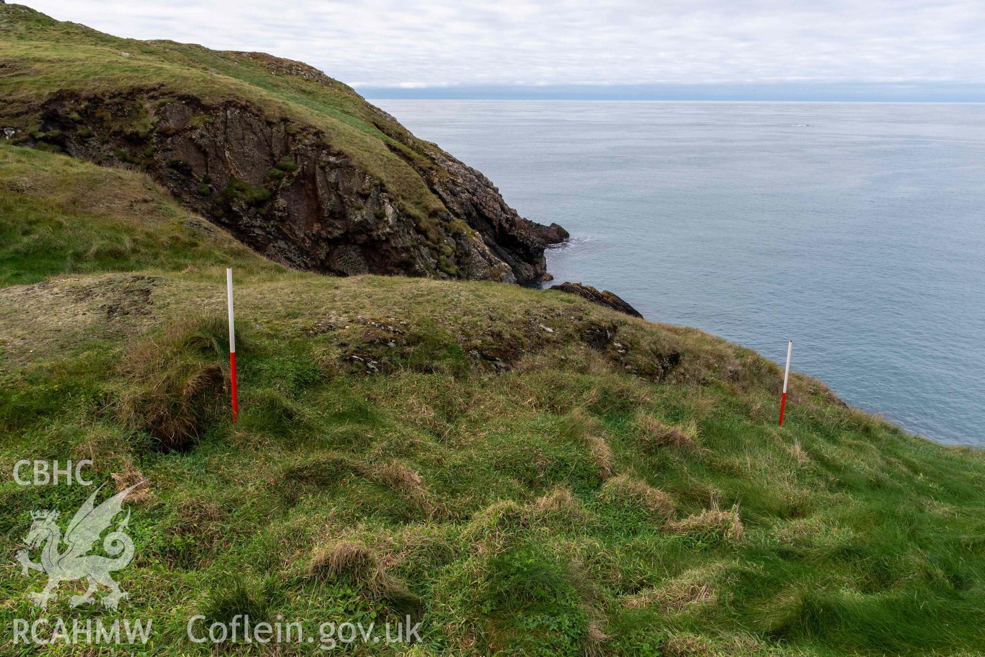 Trwyn Castell coastal promontory fort. View looking northwest over outer ditch and bank constructed across the narrowest point of the promontory (with scale).