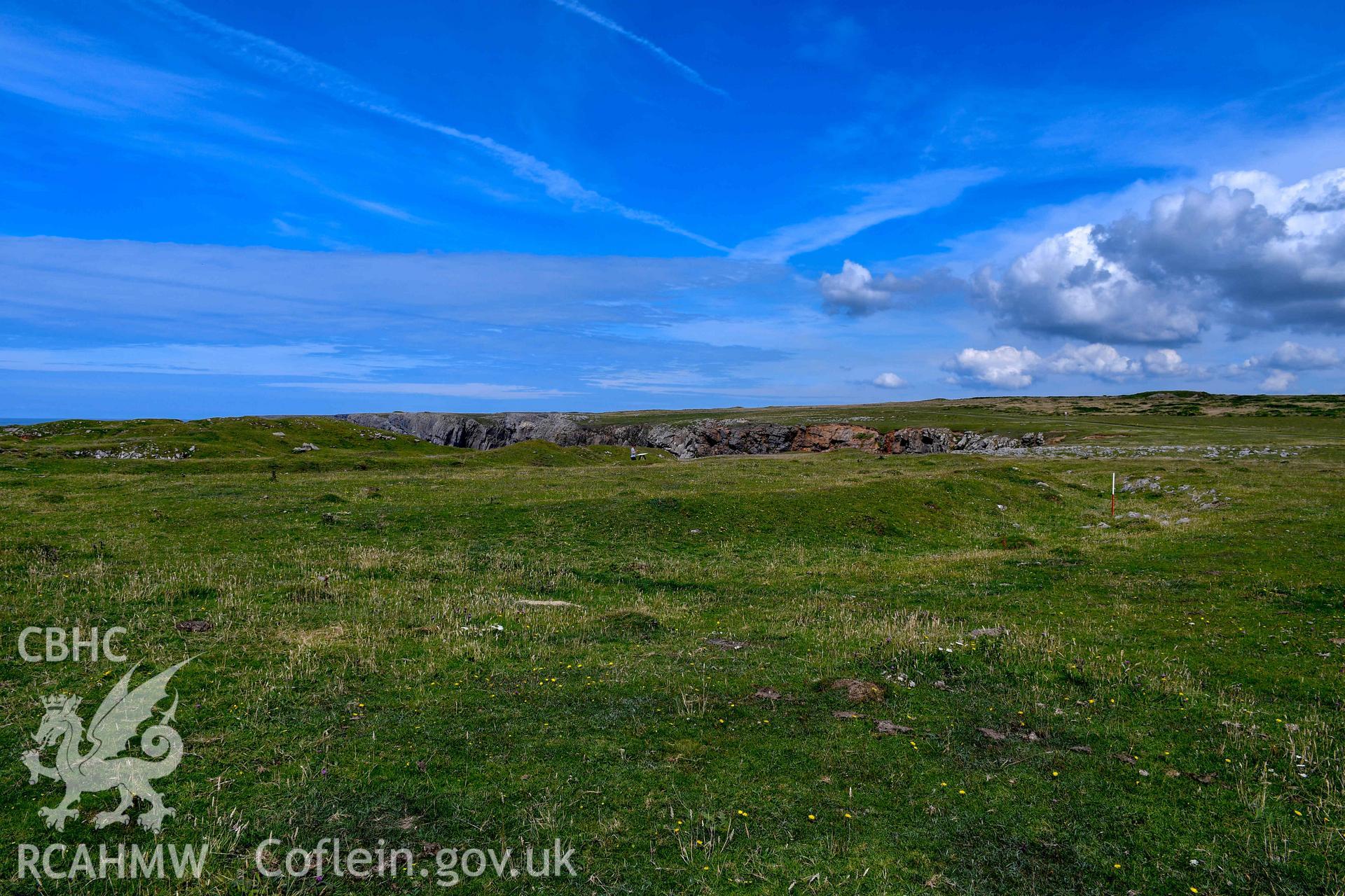 Looking northwest along the outer rock-cut ditch defining the fort (with scale).