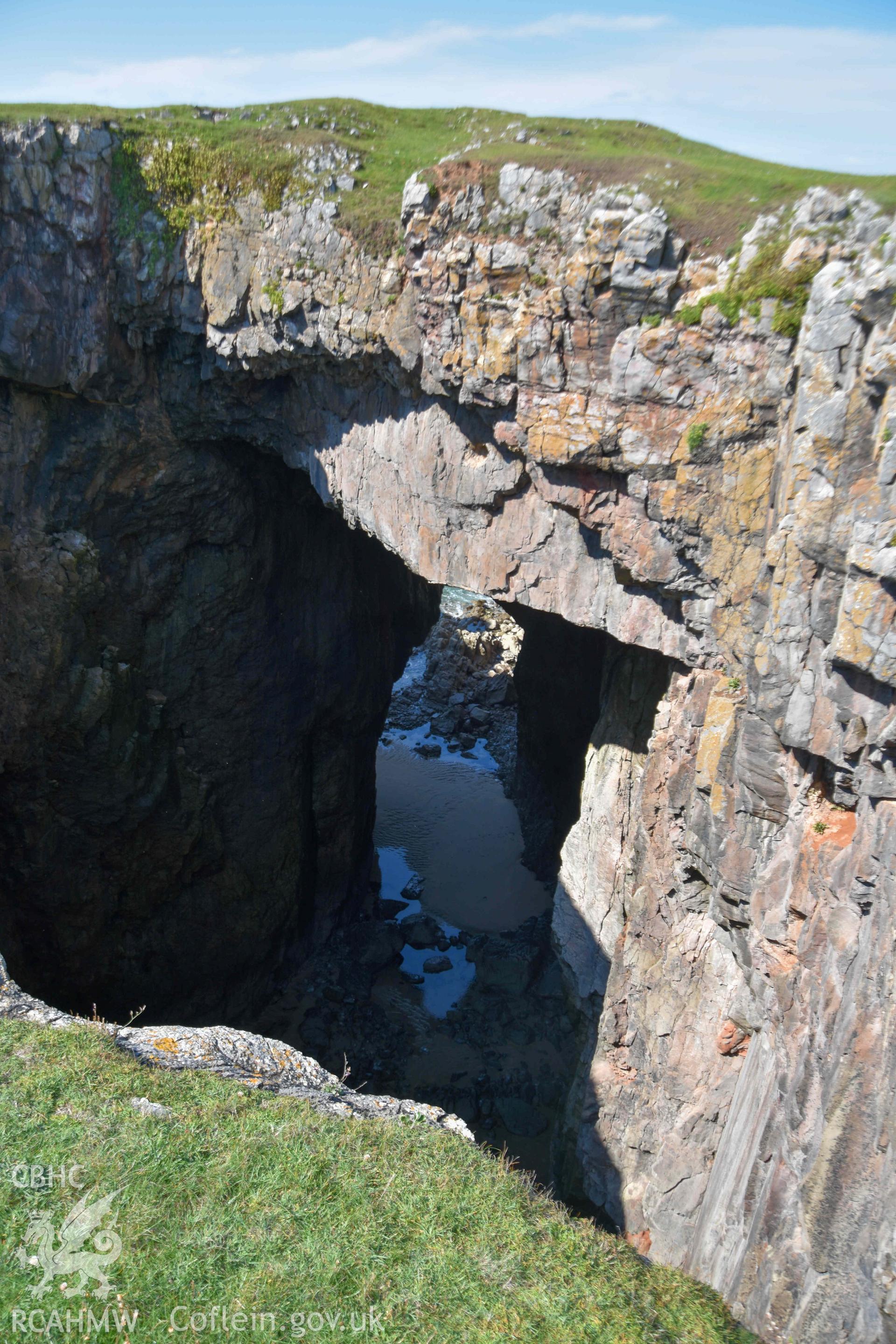 Looking north across the blow-hole to the cave running beneath the inner rampart of the fort.