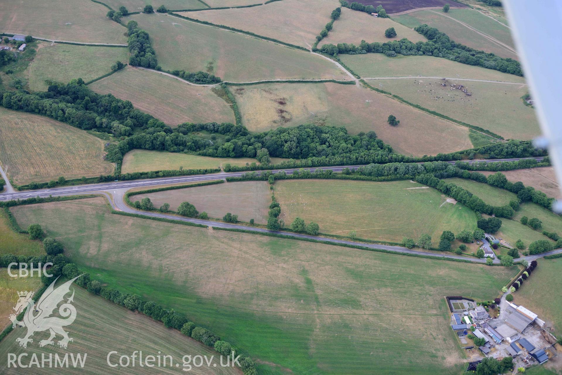 RCAHMW colour oblique aerial photograph of Round barrow cropmark at Moor taken on 17 July 2018 by Toby Driver (NGR: SN230169)