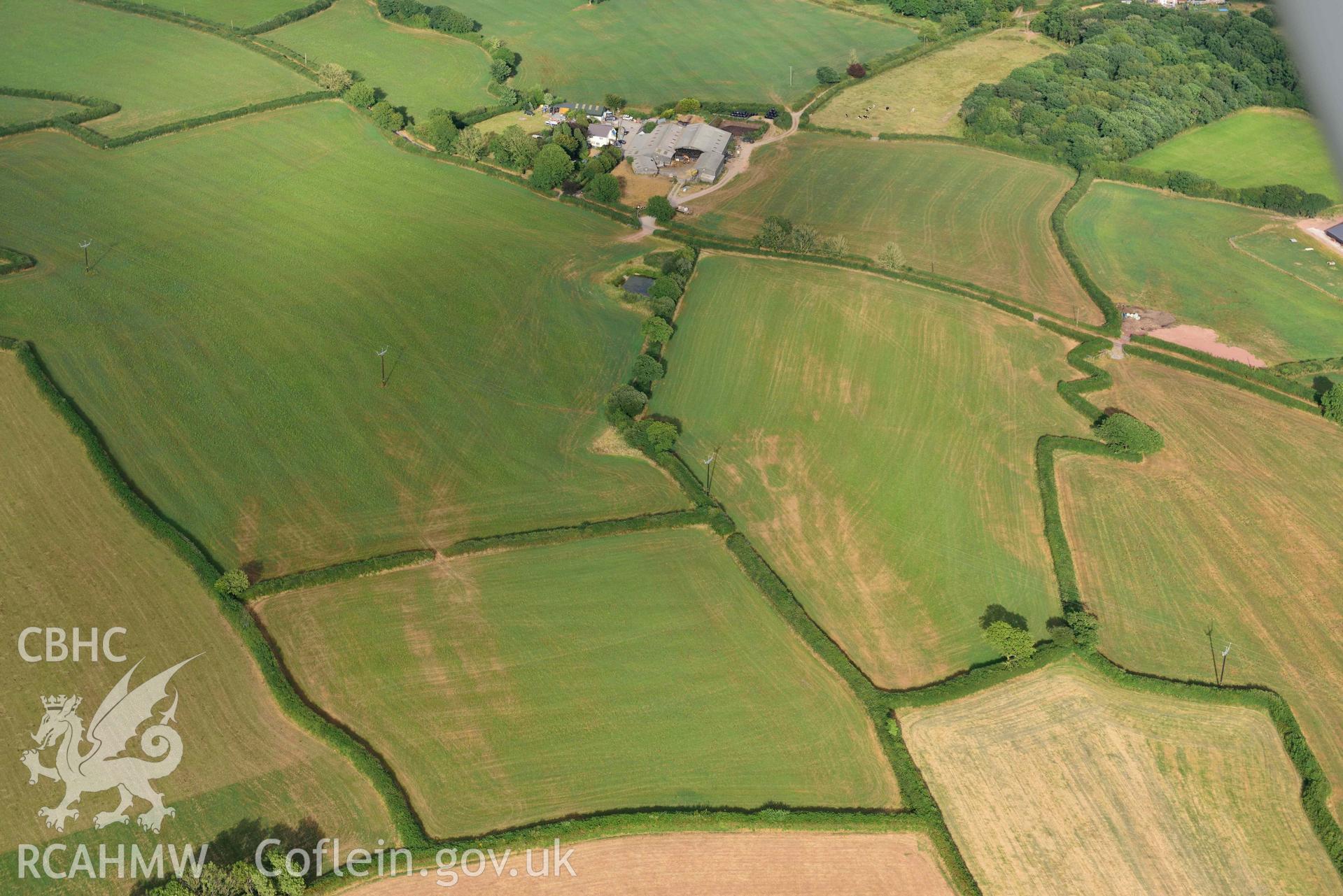 RCAHMW colour oblique aerial photograph of Roman road from Carmarthen to Kidwelly; quarry pit cropmarks west of Fforest-uchaf, view from W taken on 17 July 2018 by Toby Driver (NGR: SN412144)