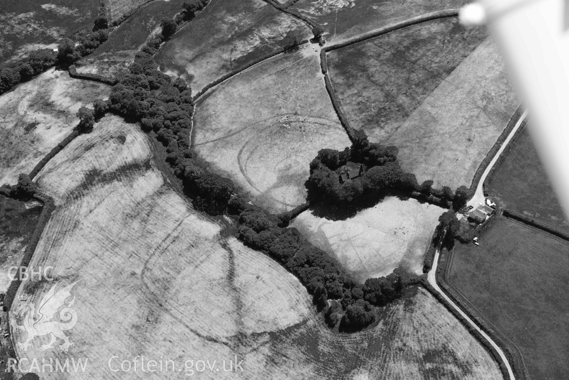 RCAHMW black and white oblique aerial photograph of  St Cannas enclosure complex taken on 9 July 2018 by Toby Driver