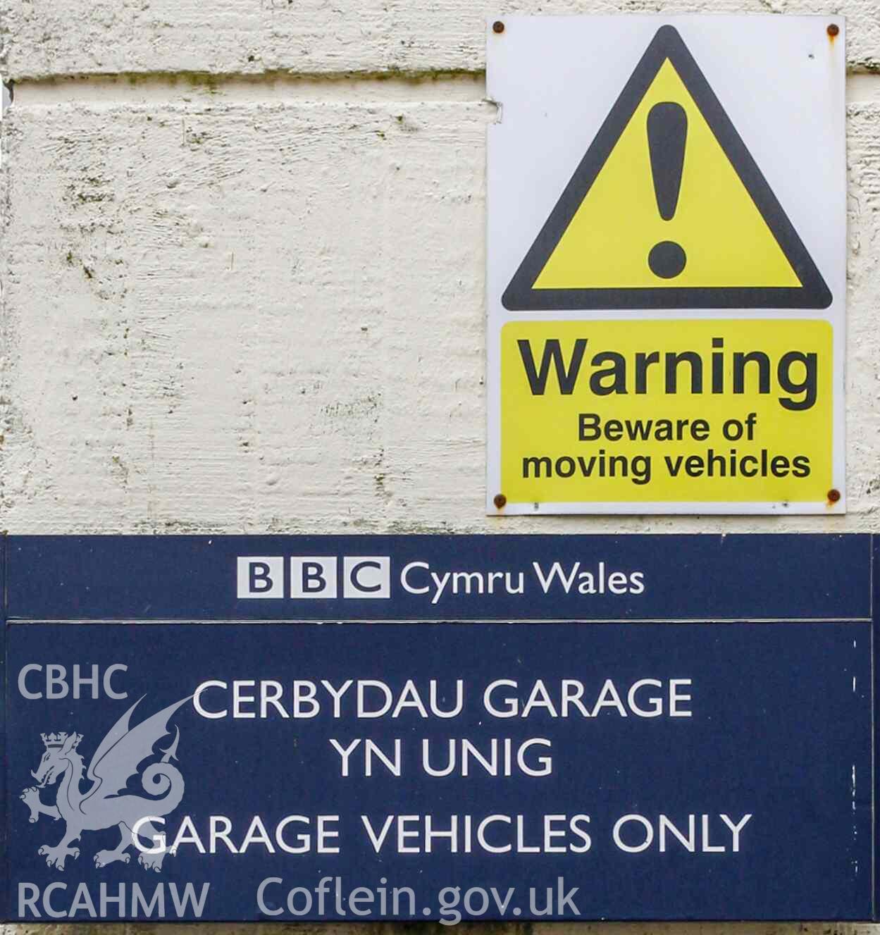 BBC Broadcasting House - Exterior, Workshops: Detailed view of a 'moving vehicles' warning sign and a BBC Cymru Wales sign reading 'Cerbydau Garage Yn Unig/Garage Vehicles Only', taken from South-West