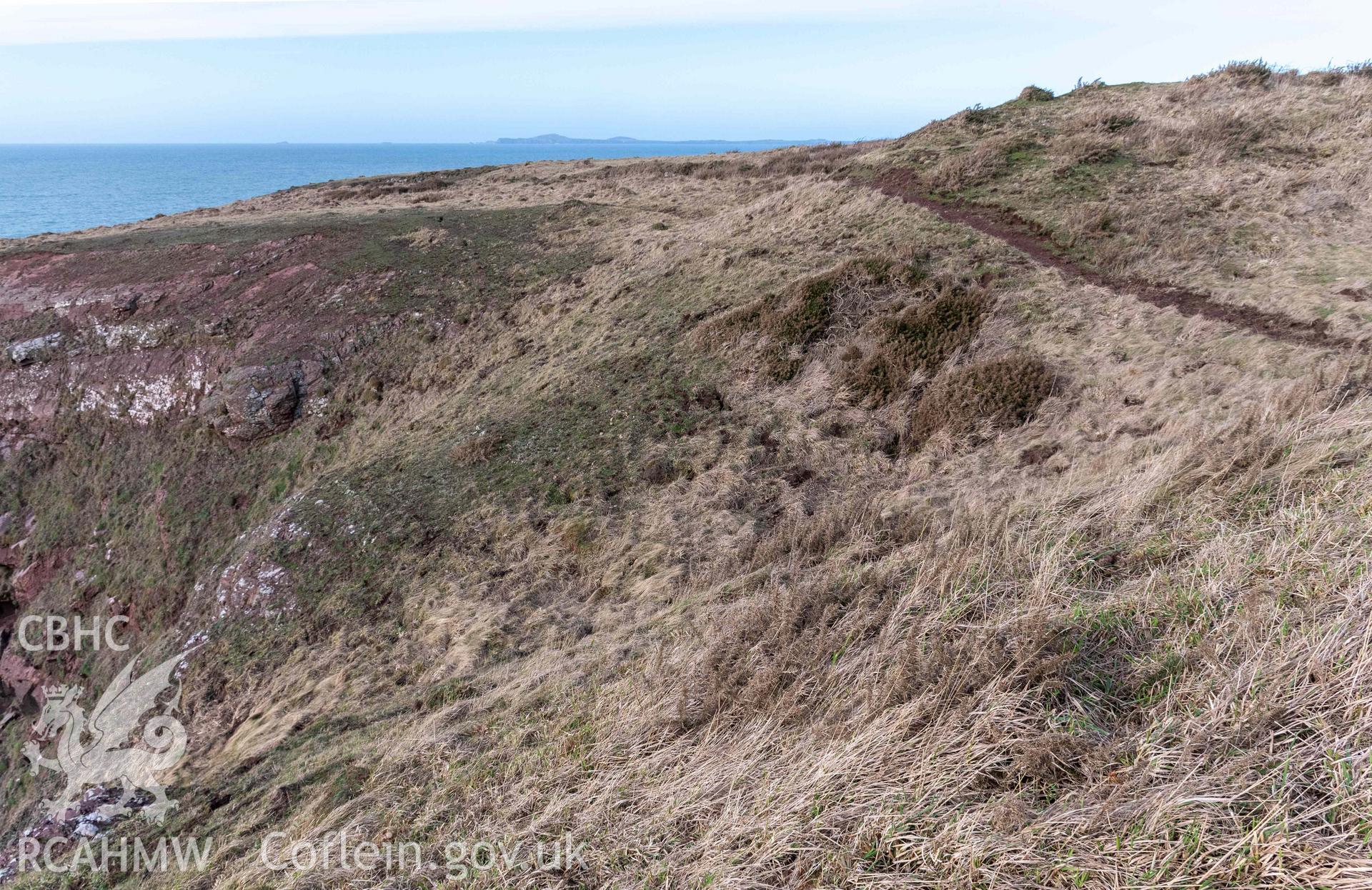 Tower Point Rath. Looking north across the defences as they meet the coast edge on the south side of the fort.