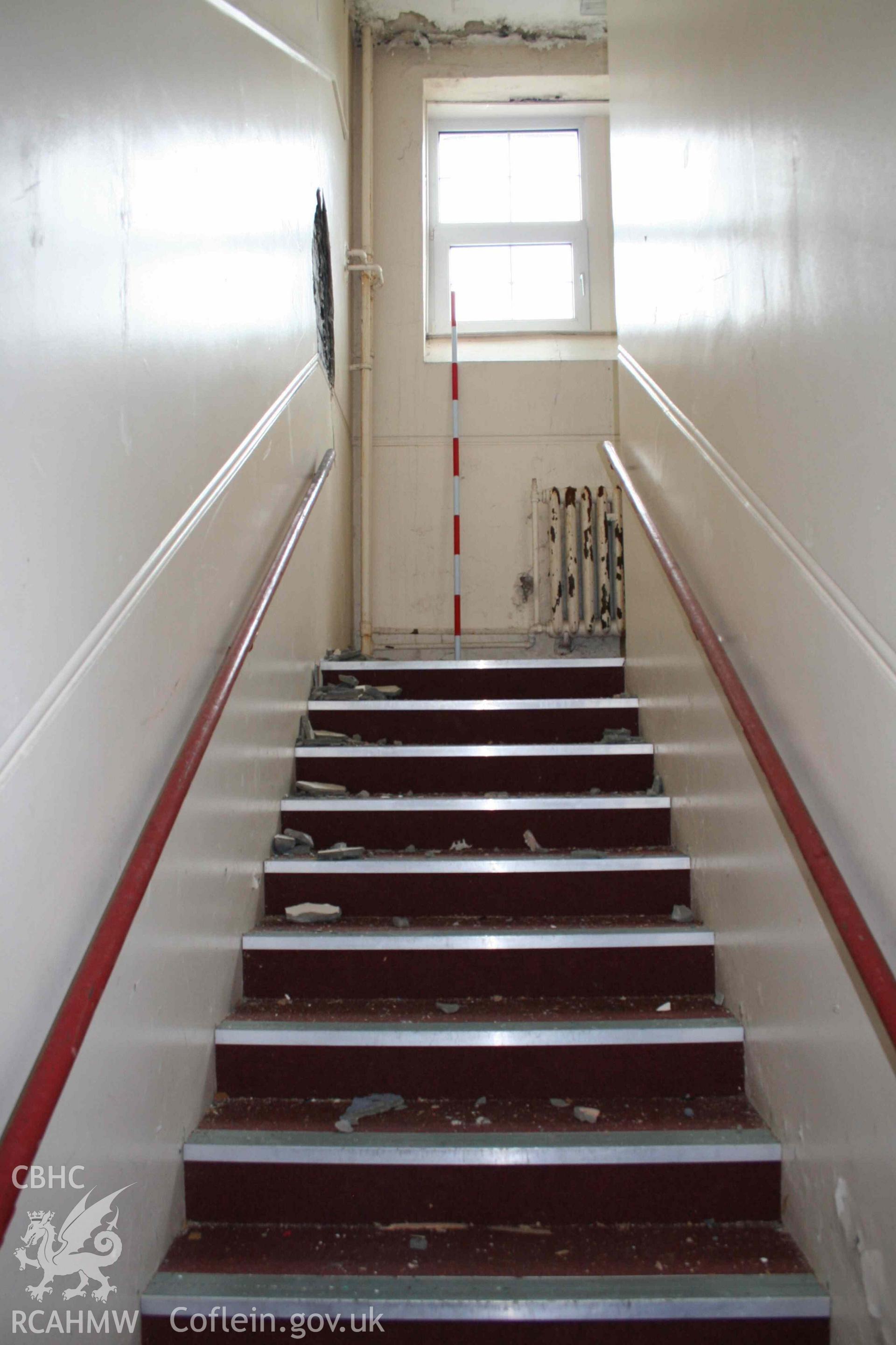 Room 15, stairs up to first floor, looking south. Photograph from an Archaeological Level 3 Building Recording for The Former Women’s Training College, UWSTD Townhill Campus, Townhill Road, Swansea. Dated 2021. Project: AW2915.