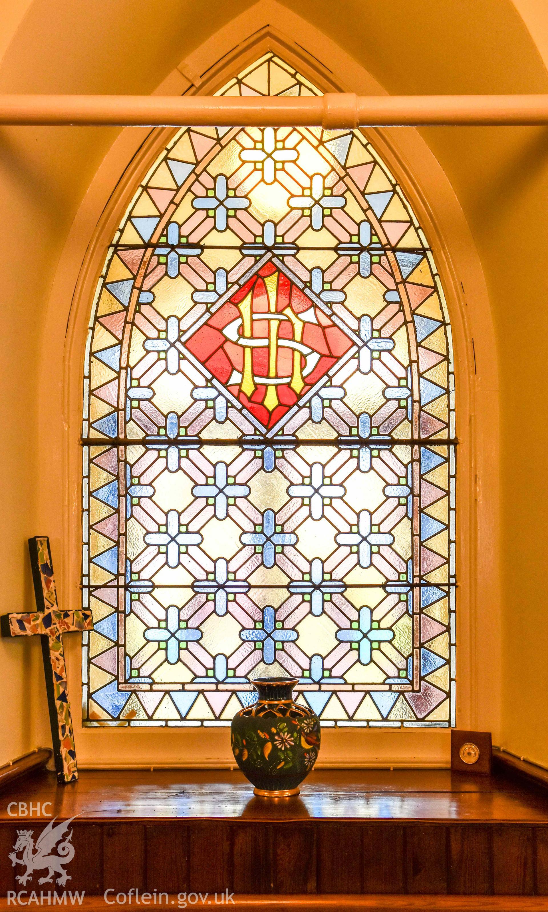 Albany Congregational Chapel - View of a stained glass window with a decorated cross, urn and temperature gauge on the sill