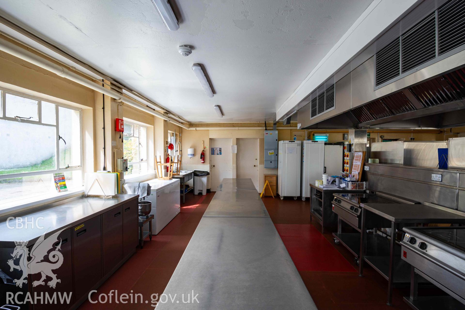 View along metal preparation tables towards rear of kitchen